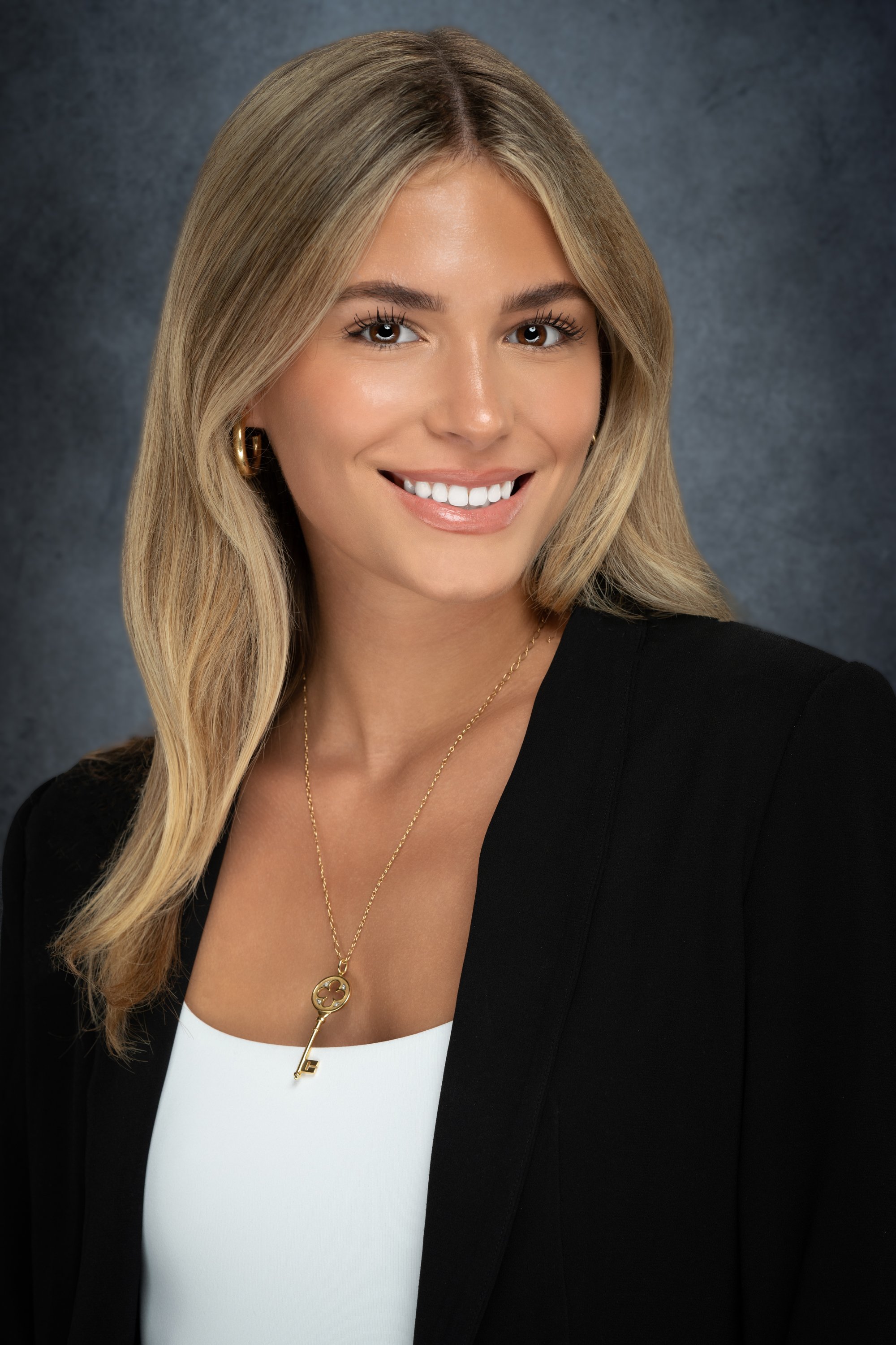 Modern corporate portrait featuring a confident professional with a natural smile, showcasing approachability and leadership in a polished studio setting.