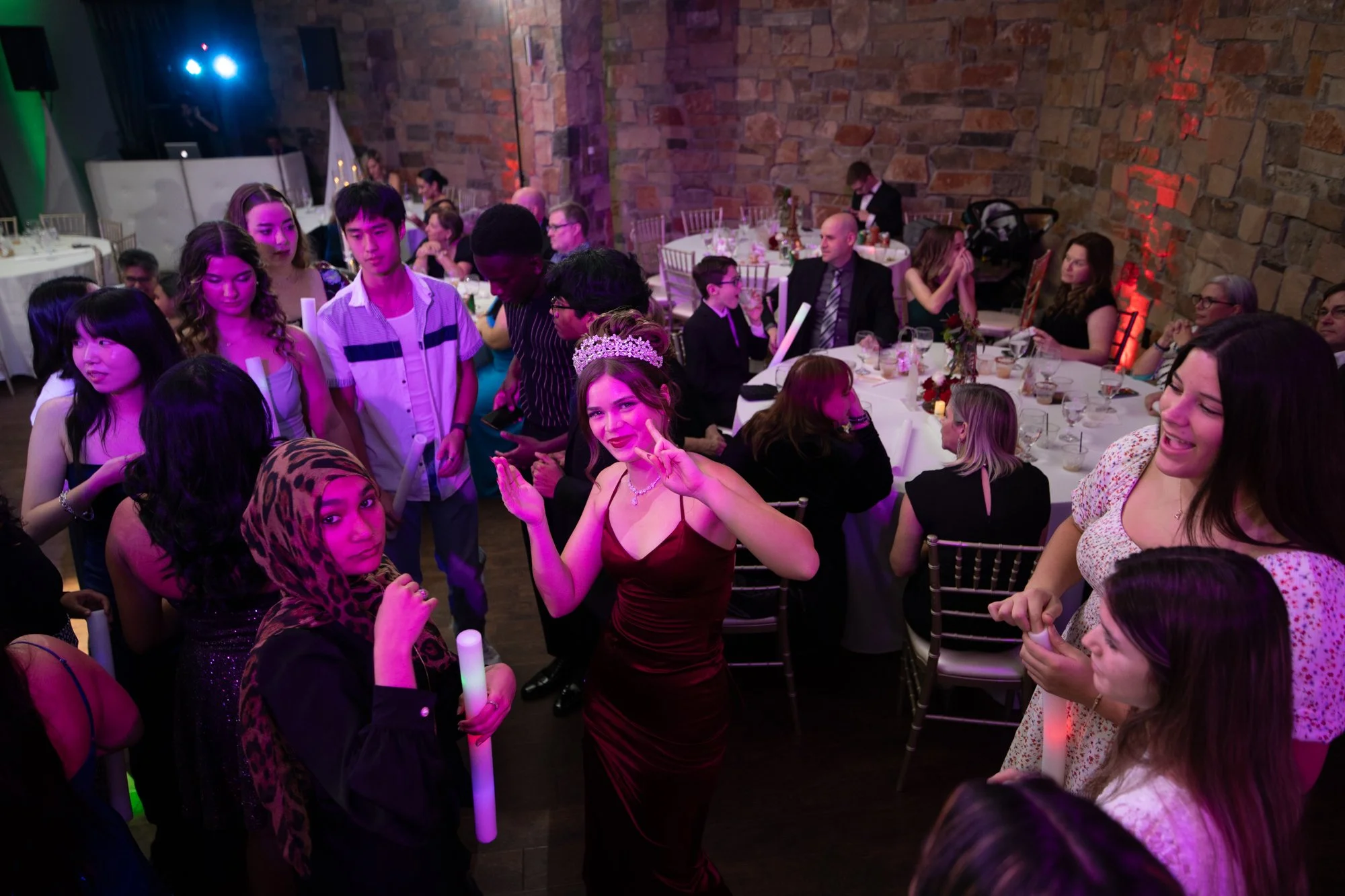 An electrifying reception scene with Alana at the center of the dance floor surrounded by friends and glowing party lights. The vibrant colors and candid expressions showcase the true spirit of a Quinceañera, fun, laughter, and memories that last for