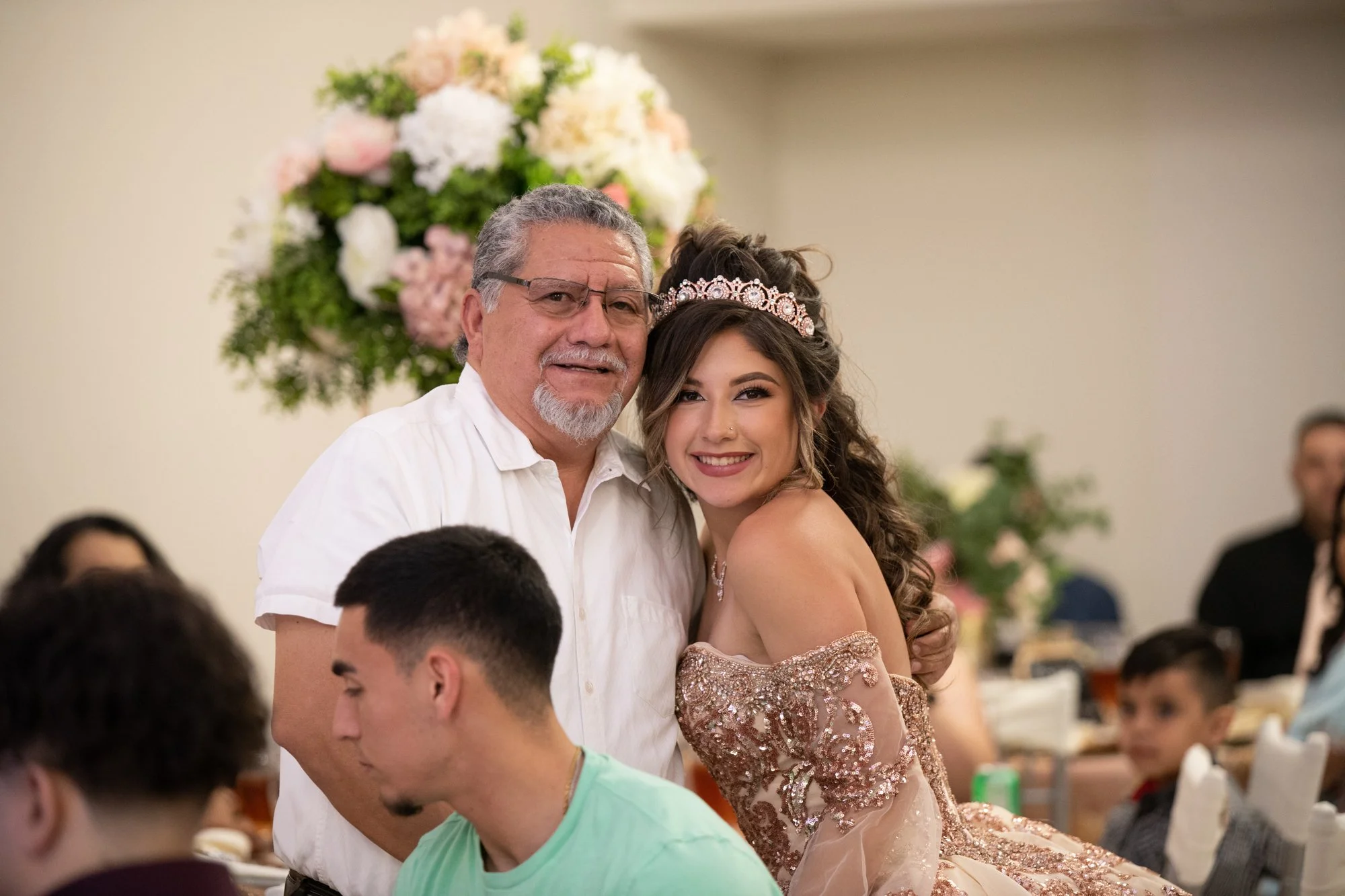 A heartfelt hug between Katelyn and her grandfather captures a tender, timeless moment. Her radiant smile paired with his proud expression reflects the deep family love that makes a Quinceañera truly unforgettable.