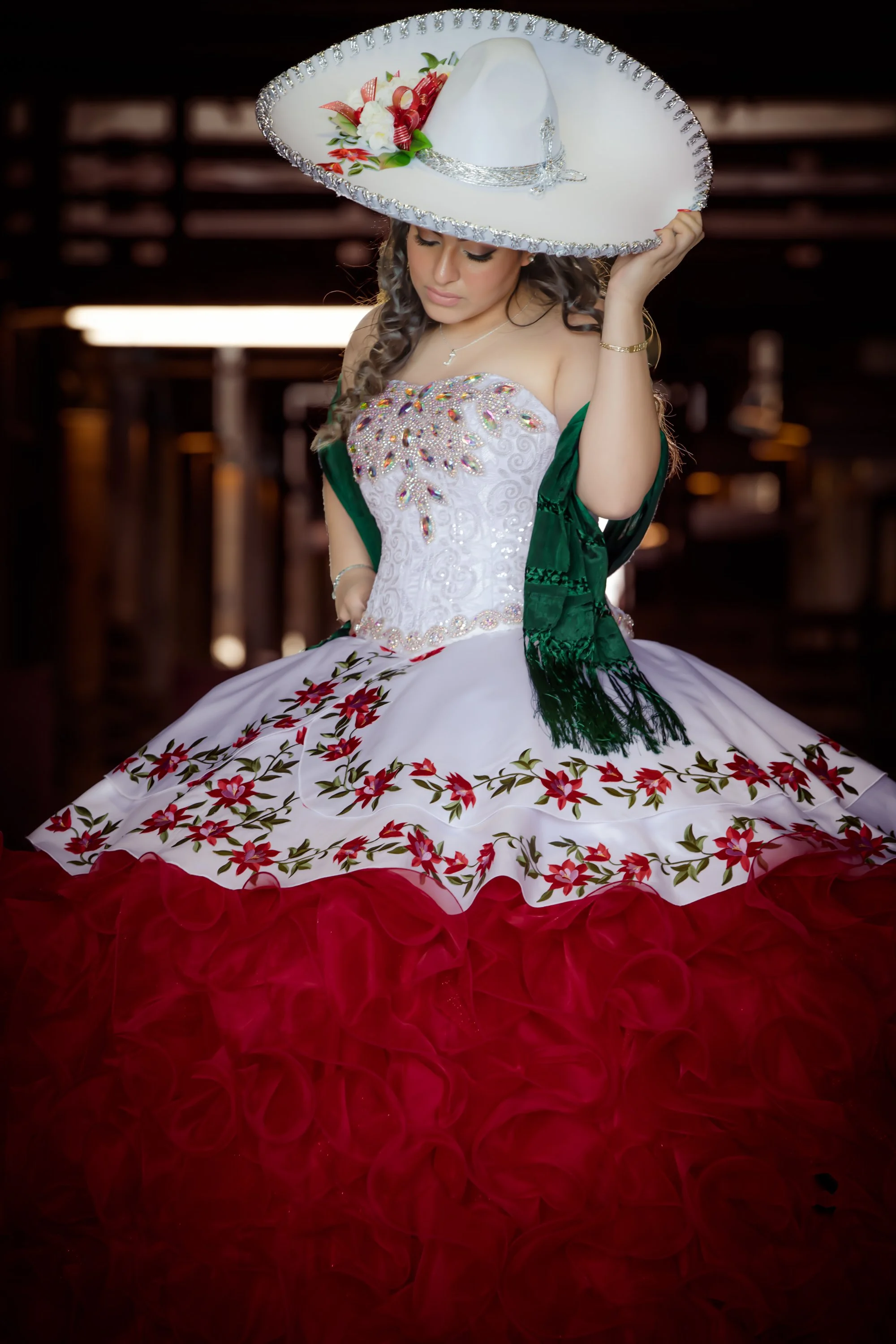 Quinceañera portrait wearing a traditional dress and sombrero.