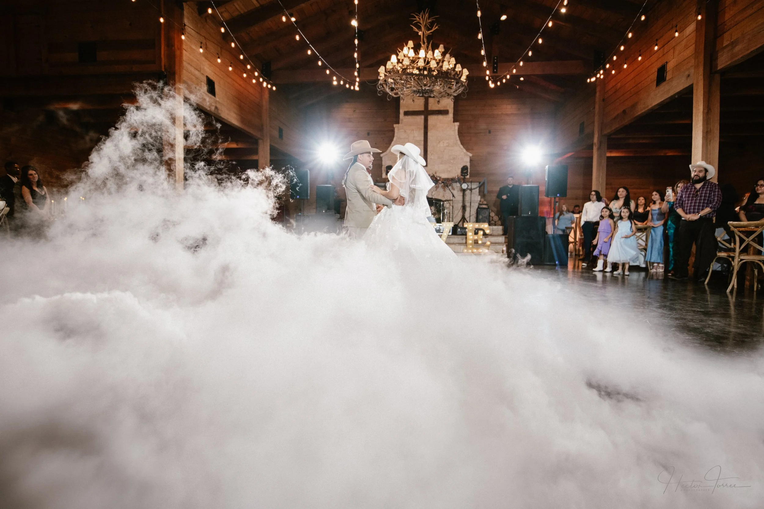 Wedding first dance with fog effect in rustic venue with bride and groom