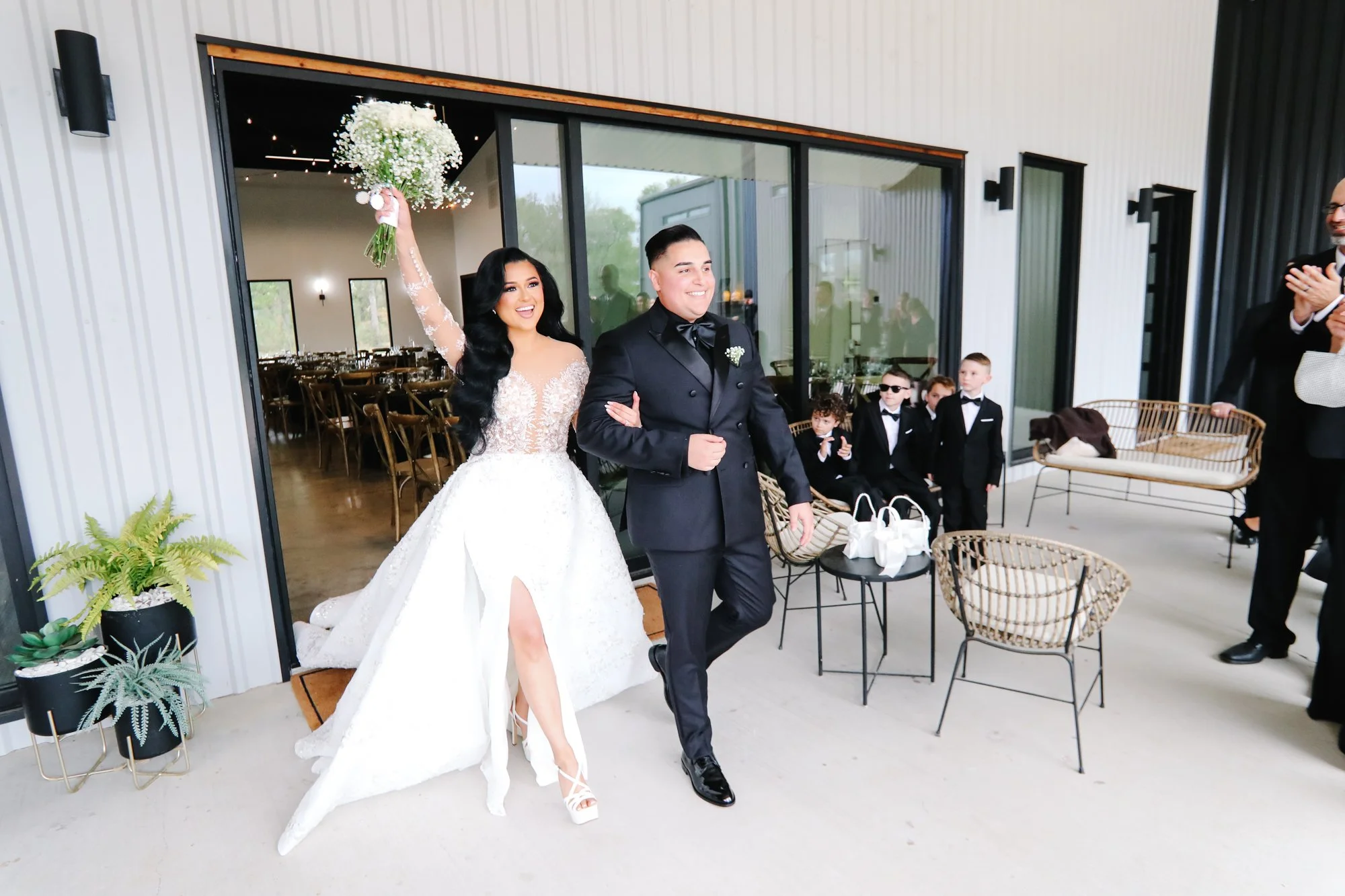 The bride and groom exit the ceremony arm-in-arm, bouquet raised high, as guests applaud—an unforgettable celebration of love and newlywed joy.