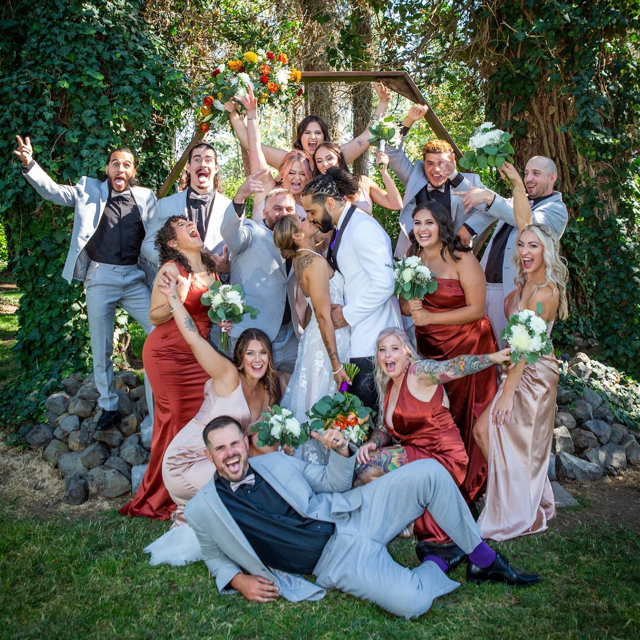 Bride and groom kissing surrounded by wedding party at a local vineyard San Antonio photographer Jeremiah Andrews