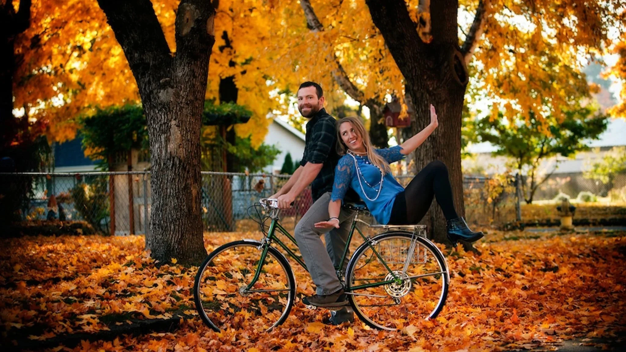 Unique engagement photo with the groom on a bike and the bride sitting backwards on the rack, creatively captured by Jeremiah Andrews, San Antonio Texas premier wedding photographer
