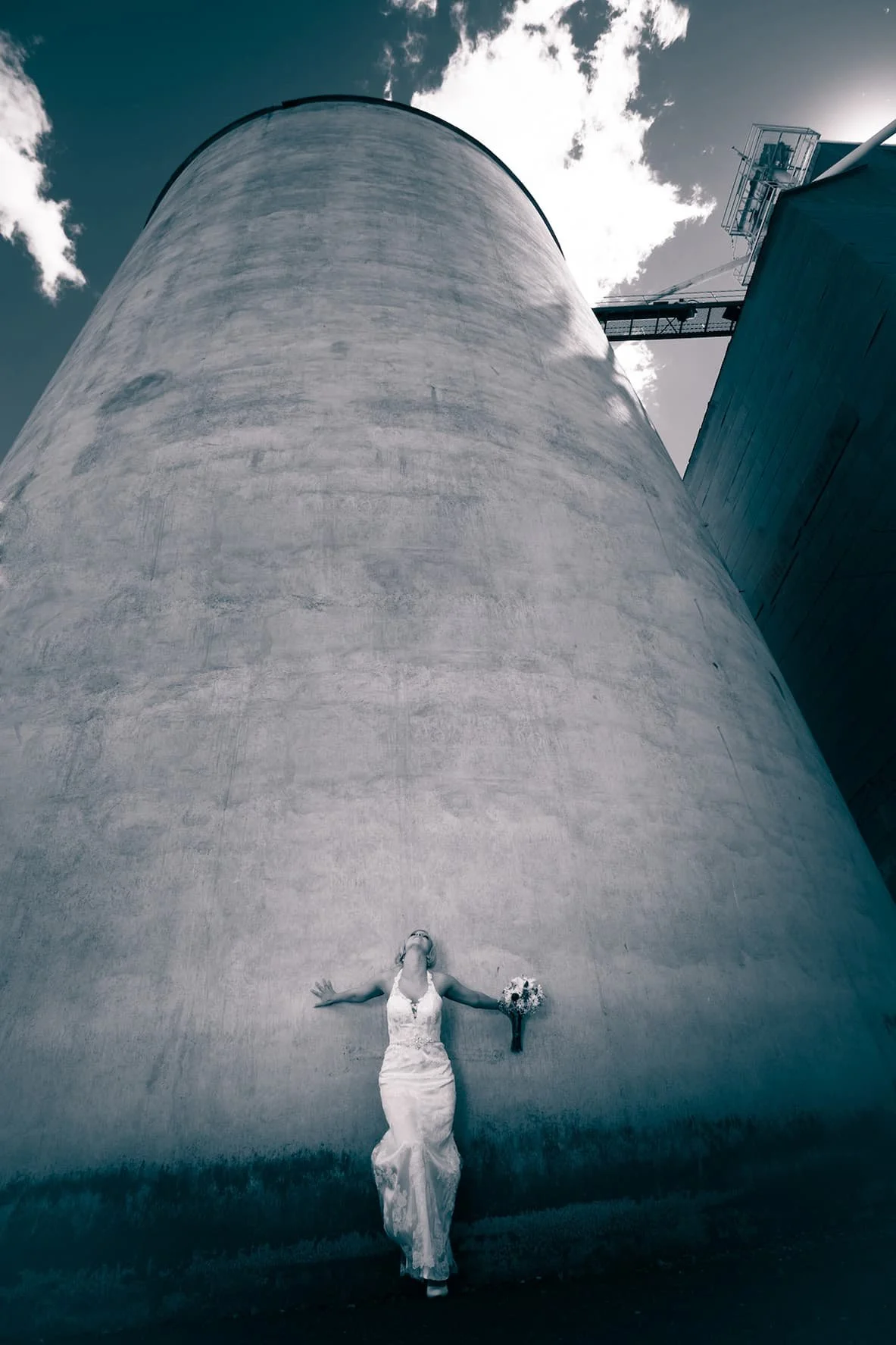 Glamour bridal portrait photographed against a textured grain silo, using natural light to create an editorial wedding image for San Antonio brides.