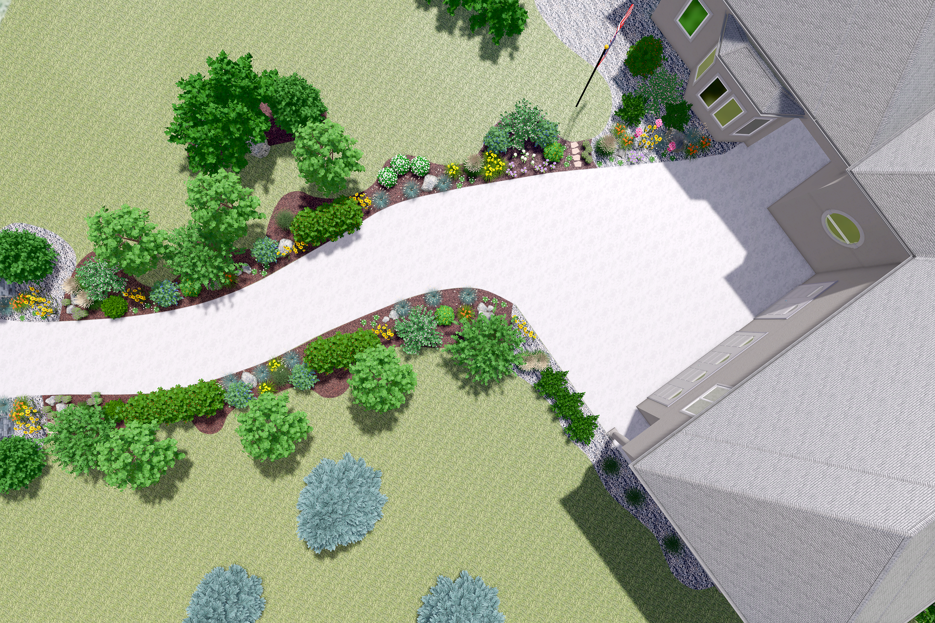 A landscaped front yard with a curved white driveway, surrounded by green grass, trees, and colorful flower beds, with a portion of a large house visible on the right side.