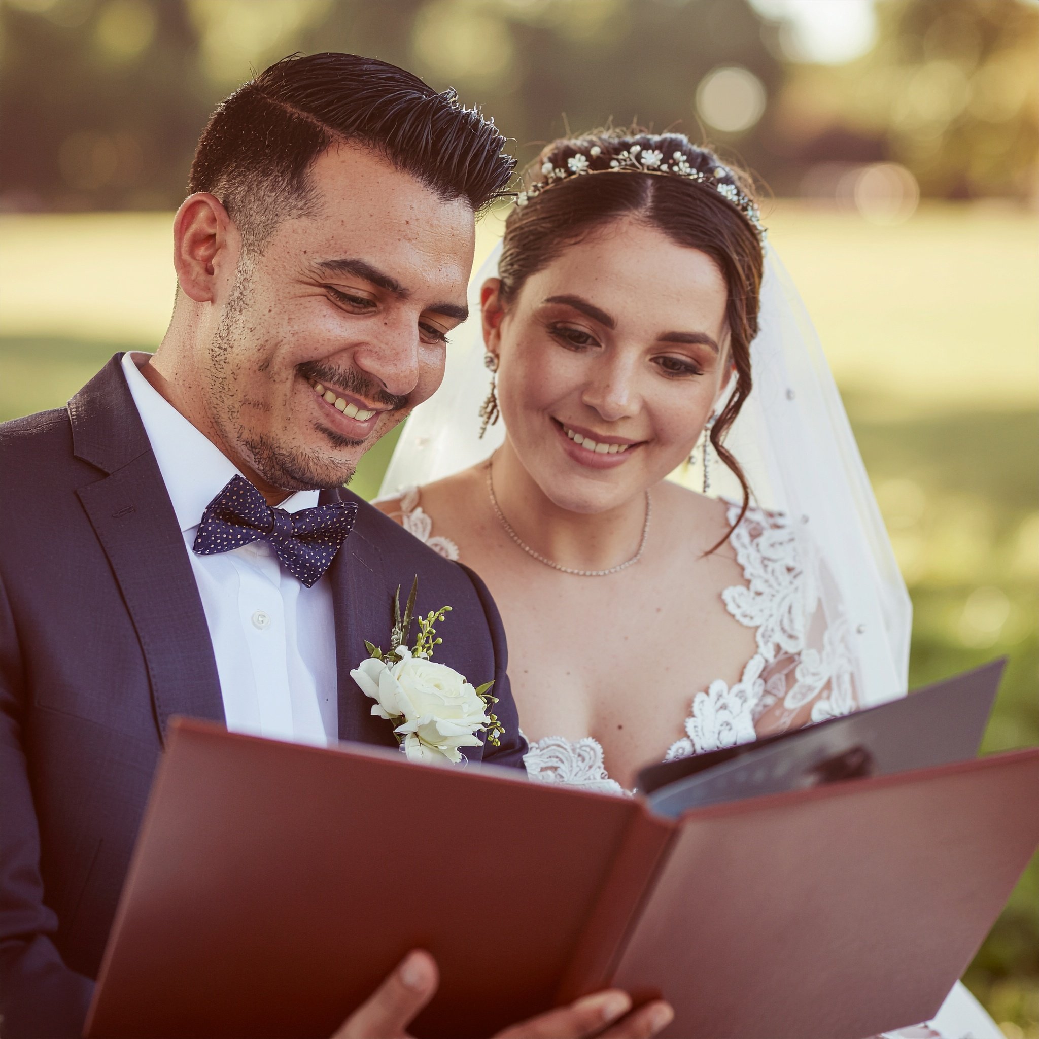 Brautpaar schaut gemeinsam Hochzeitsfotos in einem Fotoalbum an und erinnert sich an seinen Hochzeitstag