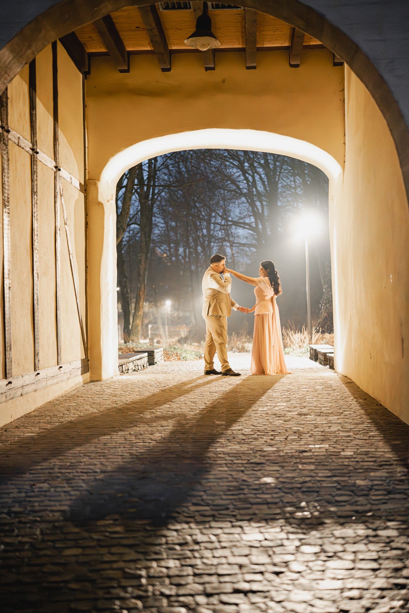 Paar tanzt bei Nacht unter Lichtertunnel – Verlobungsshooting Köln, Hochzeitsfotograf und Videograf