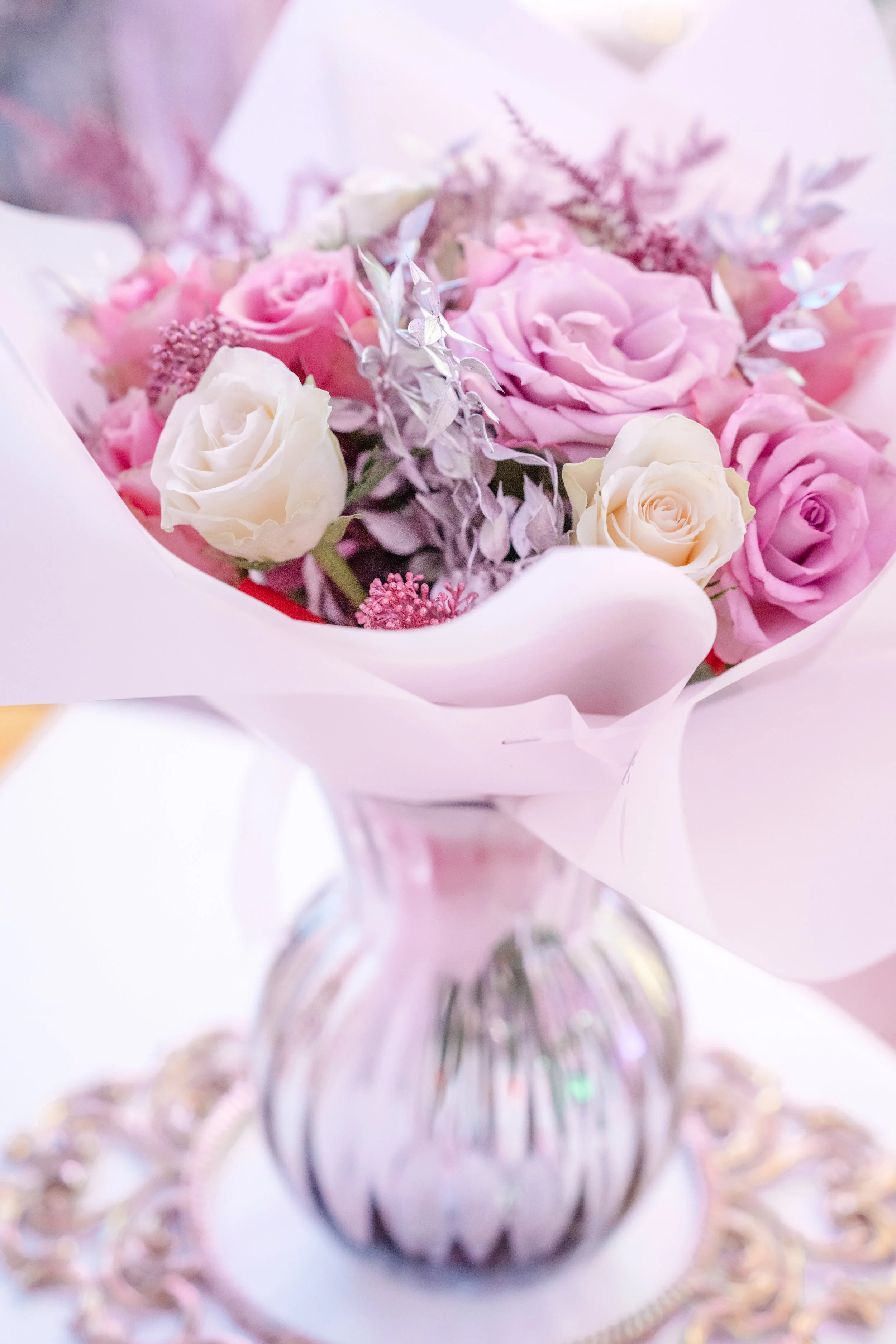 Blumenstrauß mit rosa und weißen Rosen in Vase, umgeben von Dekoration – Hochzeitsdekoration, Hochzeitsfotografie & Videografie Köln