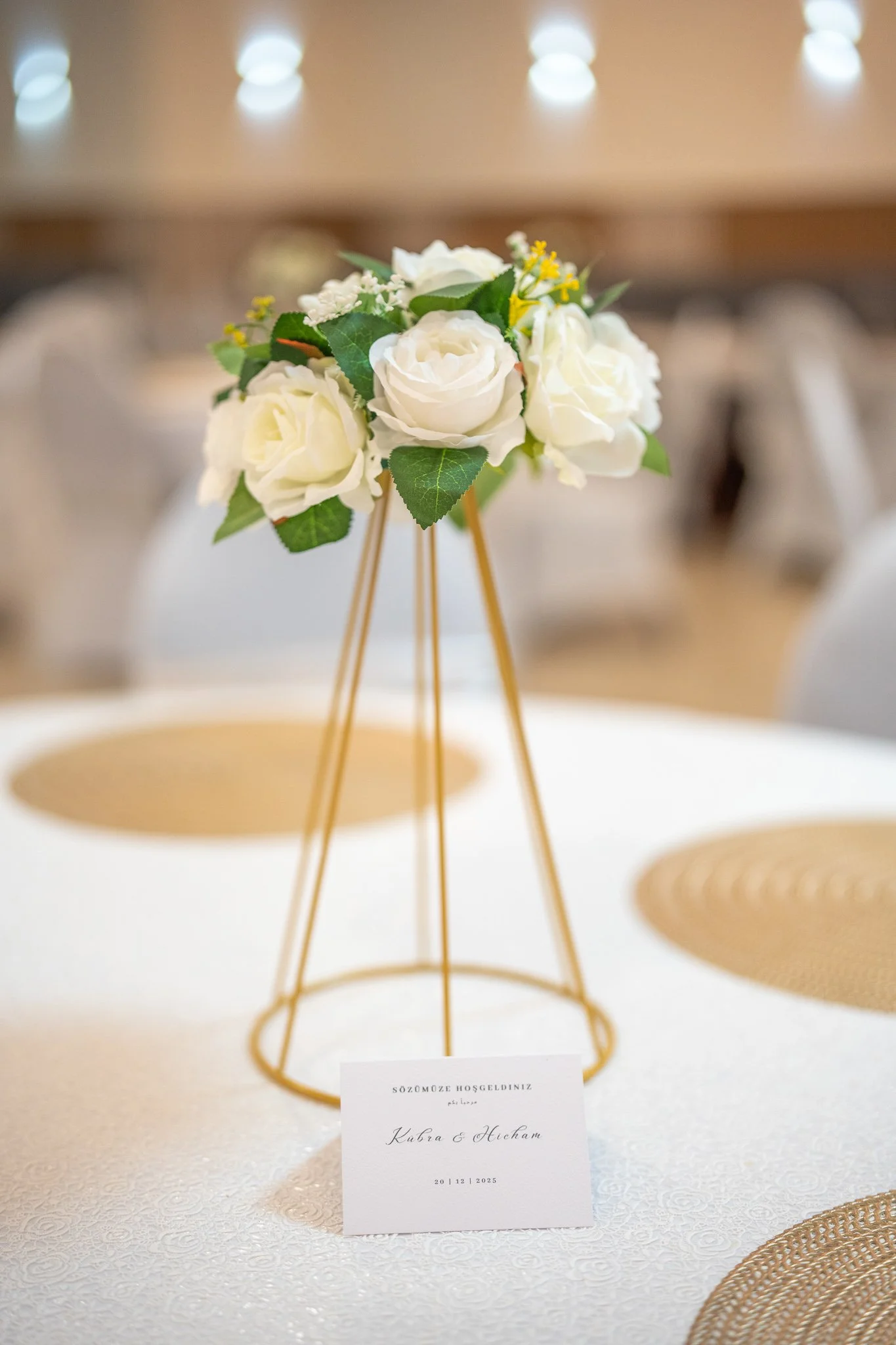 Weiße Hochzeitsblumen auf goldenem Blumenständer auf Tisch – Hochzeitsdekoration, Hochzeitsfotografie & Videografie Köln