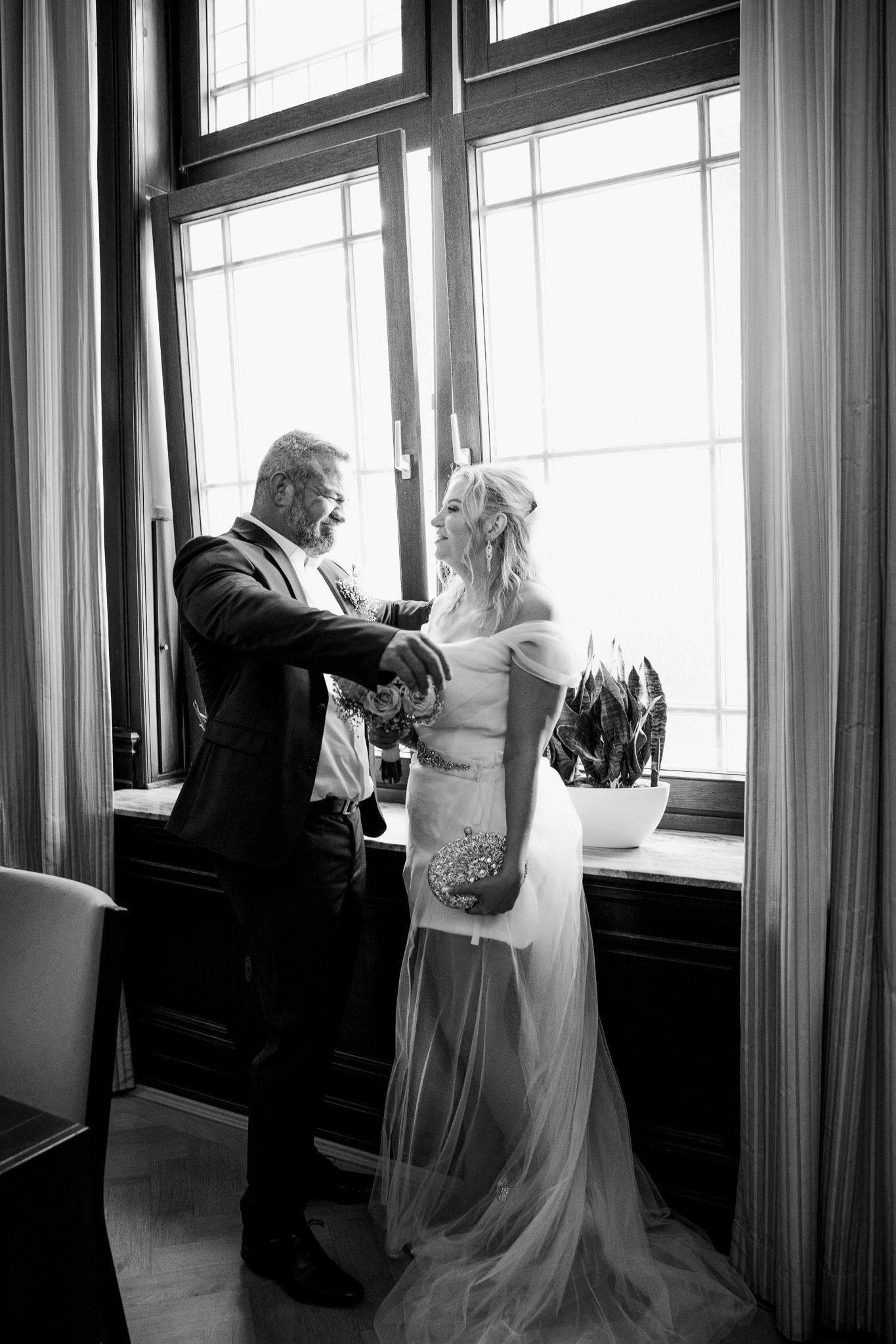 Brautpaar im Standesamt Düsseldorf – lächelnder Moment im Innenraum mit großen Fenstern, Hochzeitsfotografie & Videografie NRW