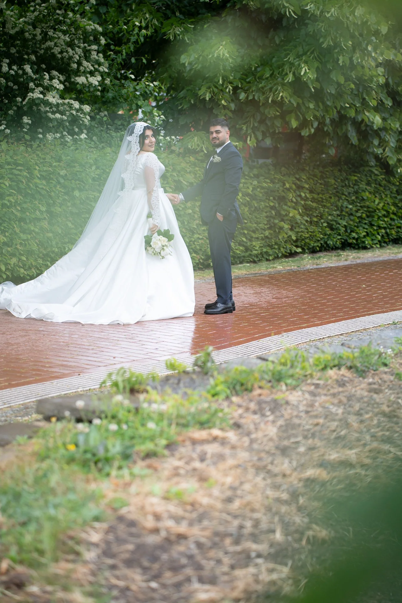 Braut und Bräutigam halten Hände im Park im Grünen – Hochzeitsfotograf und Videograf Köln