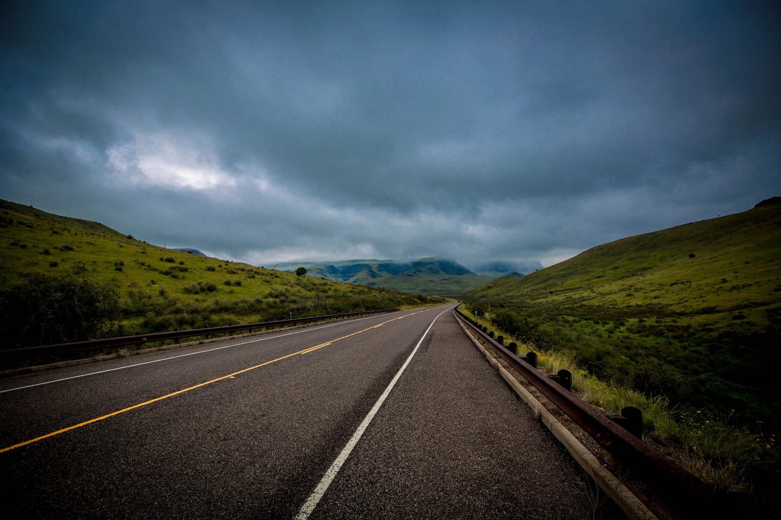 winding road with lush mountains and dramatic clouds in West Texas