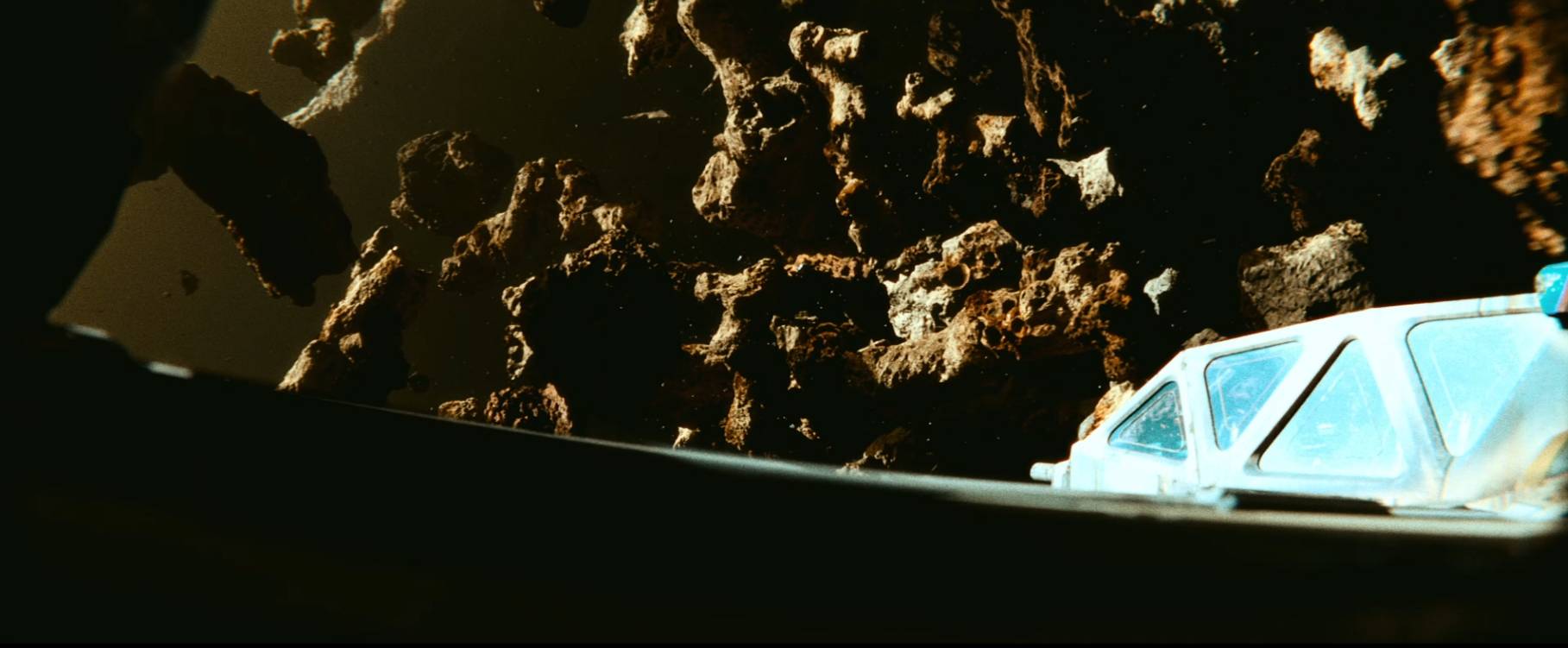 Futuristic spacecraft cockpit viewing a field of rugged asteroids in space