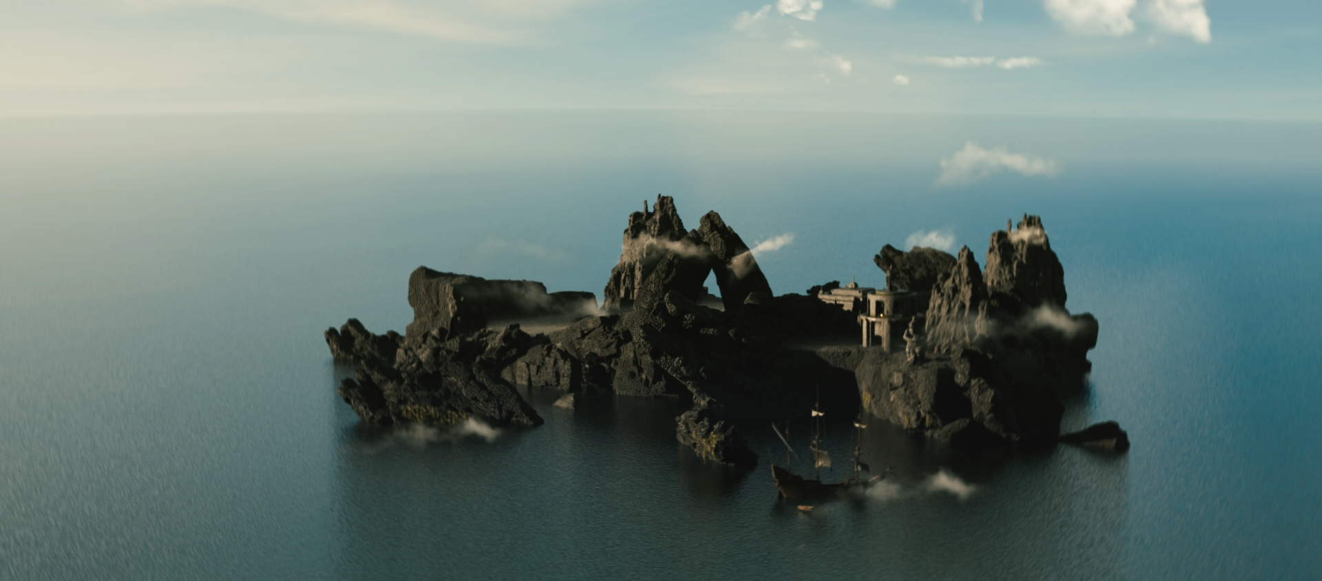 Aerial view of a jagged volcanic island with a small stone fortress, mist, and a sailing ship surrounded by calm blue ocean