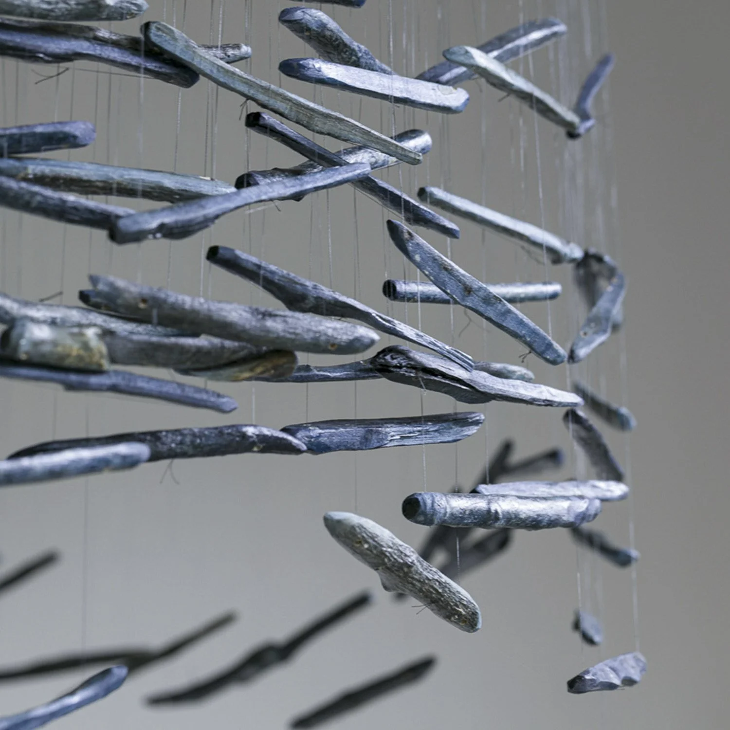 Detail View of the Horseshoe Bend Suspended Sculpture created by Theresa Clowes, shown at Walker Fine Art Gallery, Denver. A close-up look at a public art installation featuring indigo-dyed cottonwood sticks resembling the Colorado River's Horseshoe 
