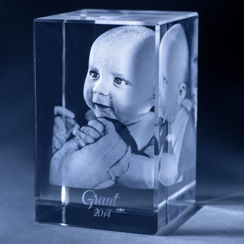 A crystal block with a photo of a baby engraved on it, holding hands and looking to the side, with the text "Giant 2014" engraved at the bottom.