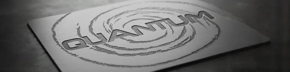 A printed sheet of paper with the word 'QUANTUM' inside concentric circles, placed on a flat surface.