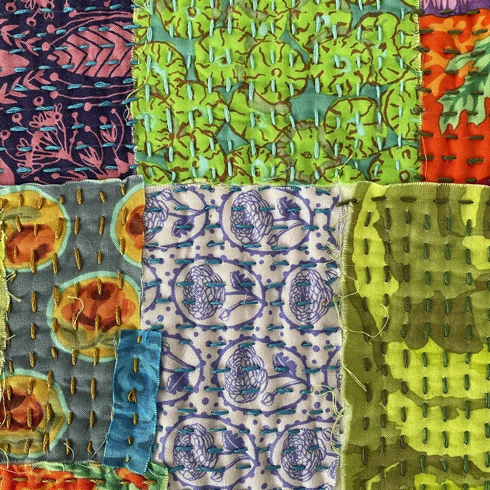 Close-up of a patchwork quilt with various colorful fabrics stitched together.