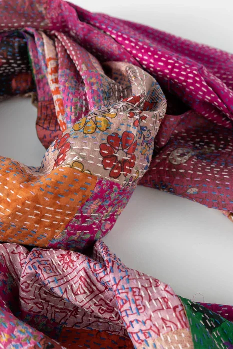 Colorful, patchwork-style fabric with various embroidered and woven patterns.