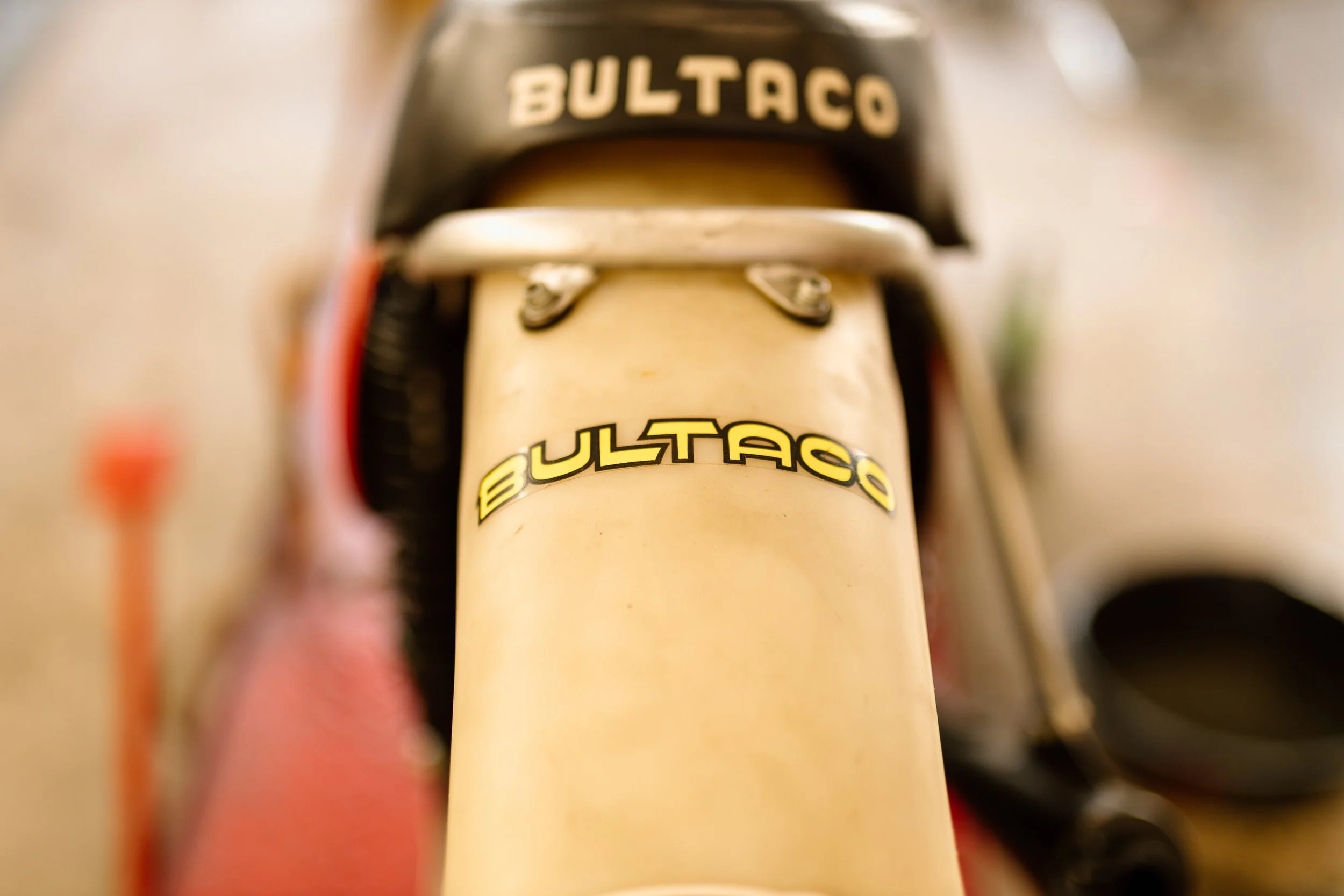 Close-up of a vintage Bultaco motorcycle's front fork with the Bultaco logo on it.