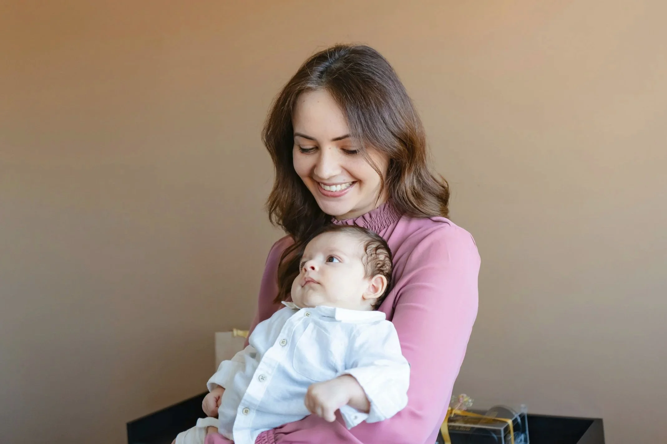 A mother holding her baby during a lactation consultation, illustrating the calm and supportive environment at Milk & Motion in Spokane.