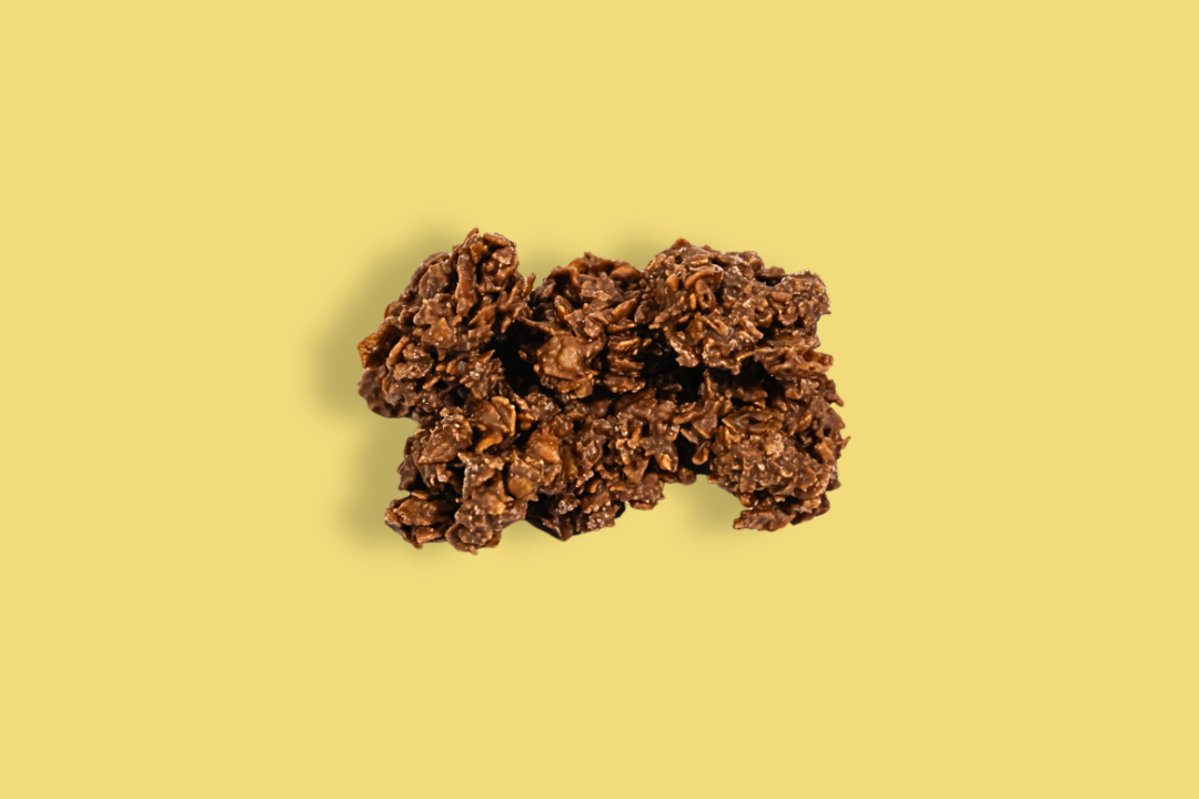 A close-up of a chocolate granola bar on a yellow background.