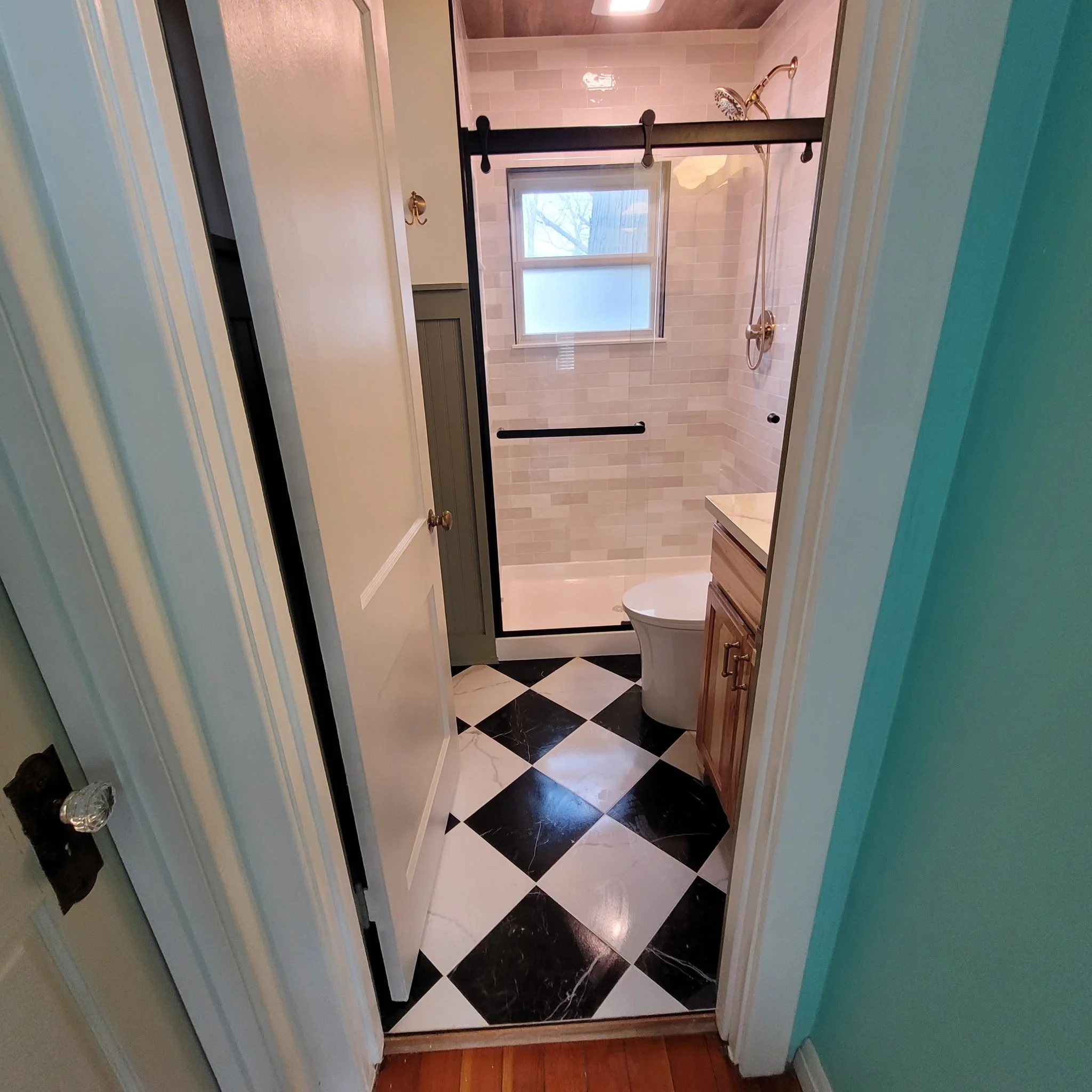 Finished bathroom remodel with checkered flooring, wood ceiling and beam, updated shower and vanity with a farm house feel.