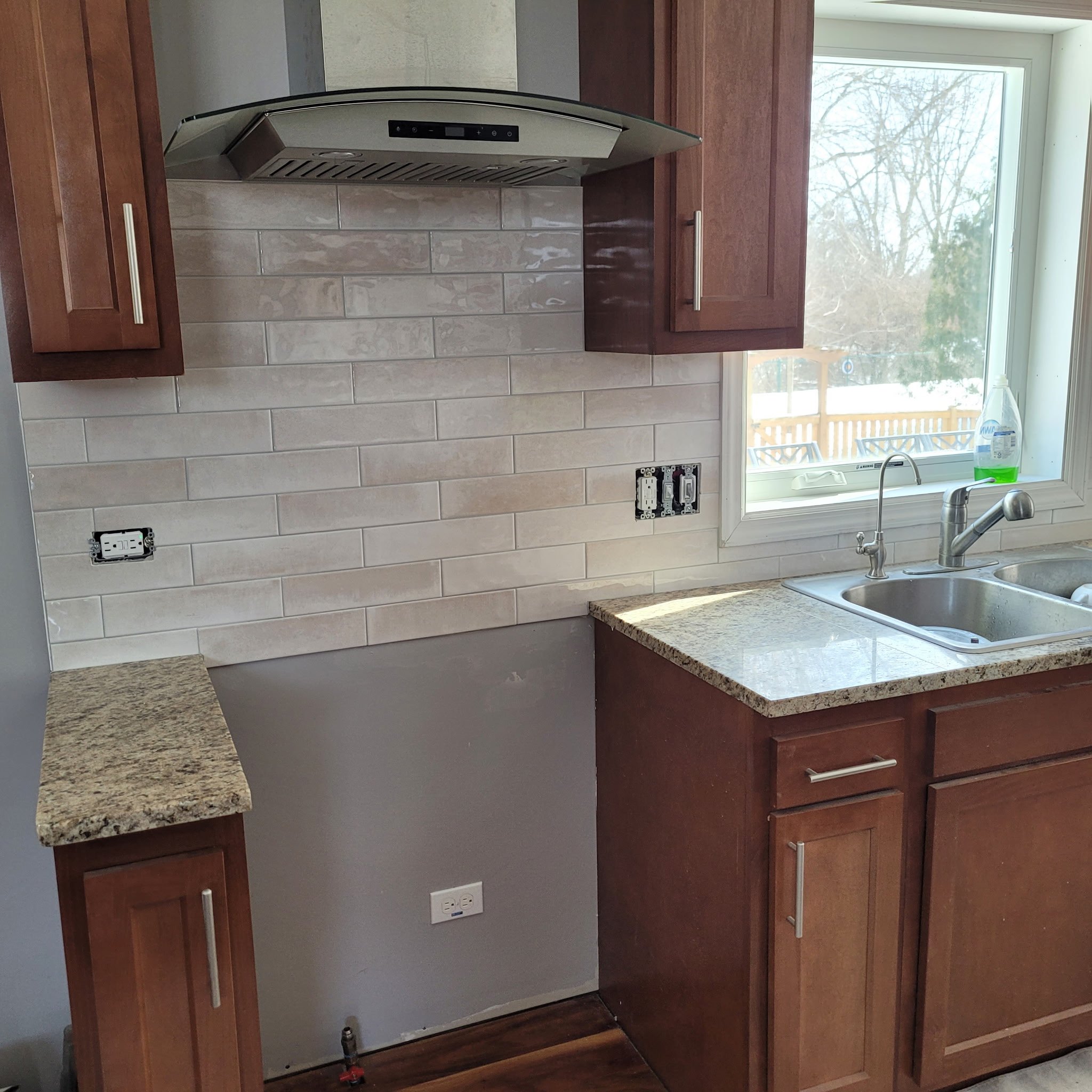 Finished kitchen remodel with new cabinets, counter tops, subway backsplash, country sink, new flooring built with a modern touch.