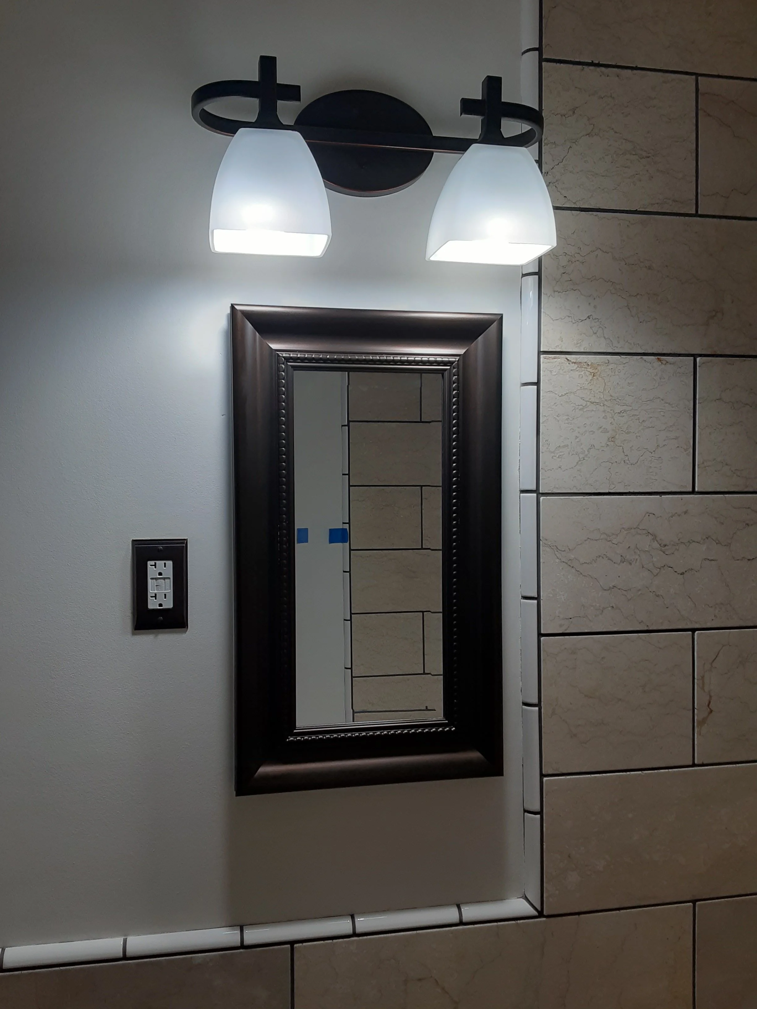new bathroom mirror and lighting with new painted walls and tile