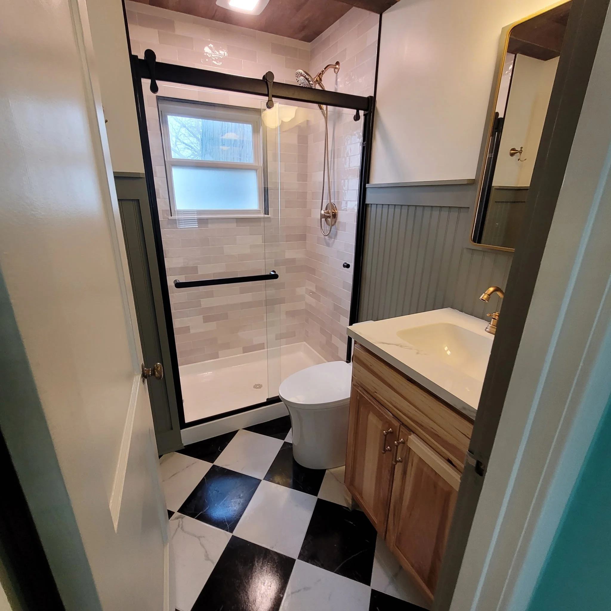 Finished bathroom remodel with checkered flooring, wood ceiling and beam, updated shower and vanity with a farm house feel.