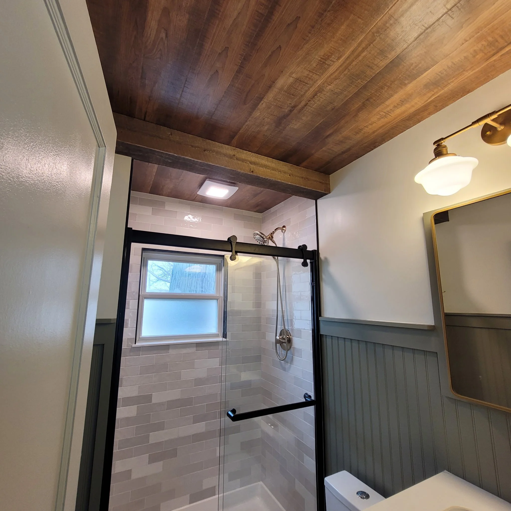 Finished bathroom remodel with checkered flooring, wood ceiling and beam, updated shower and vanity with a farm house feel.