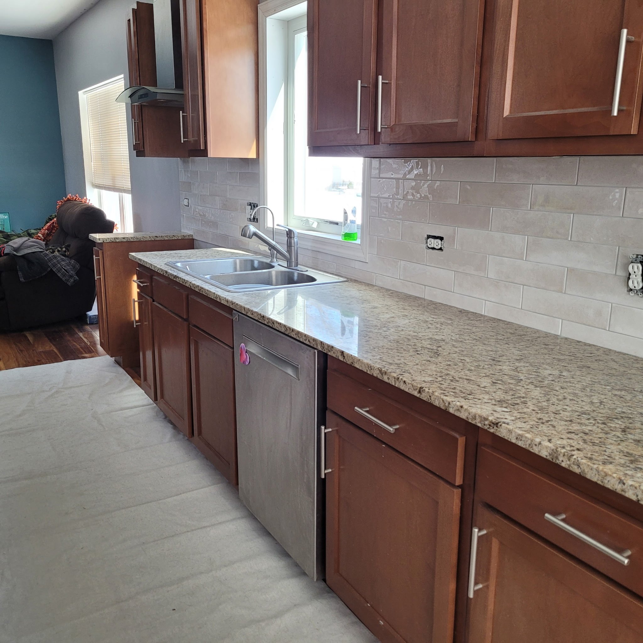 Finished kitchen remodel with new cabinets, counter tops, subway backsplash, country sink, new flooring built with a modern touch.