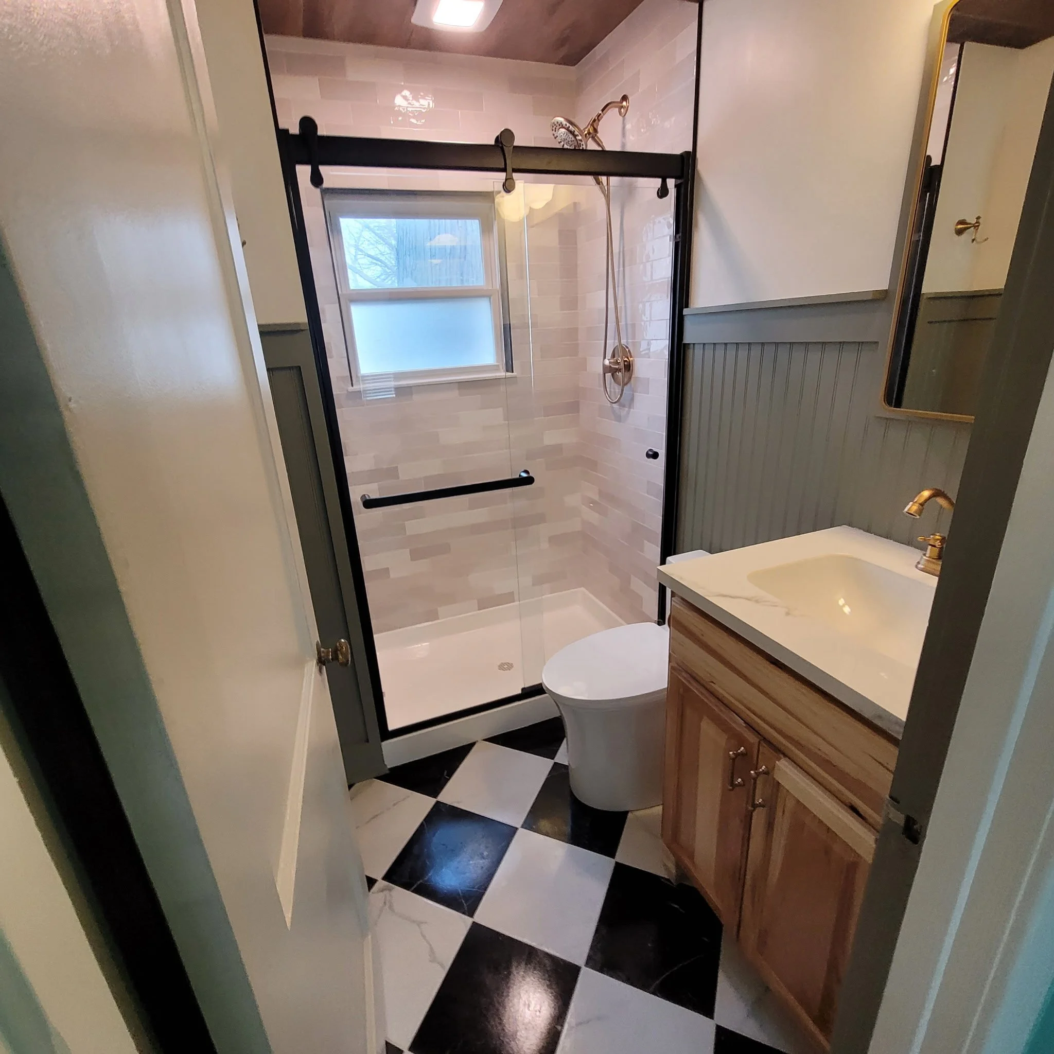Finished bathroom remodel with checkered flooring, wood ceiling and beam, updated shower and vanity with a farm house feel.