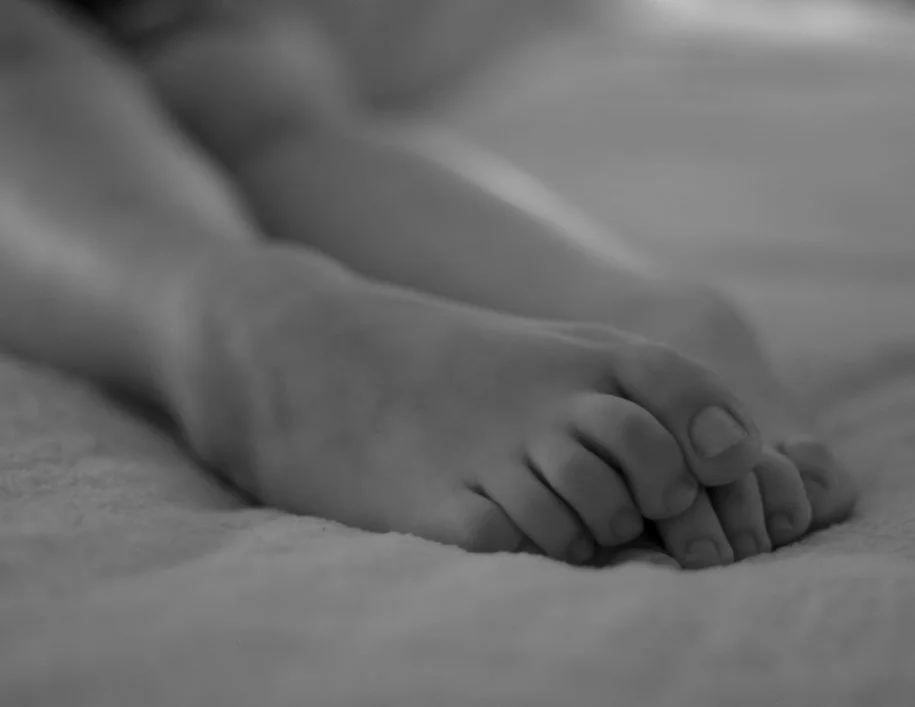 Close-up of a child's hand resting on a surface.