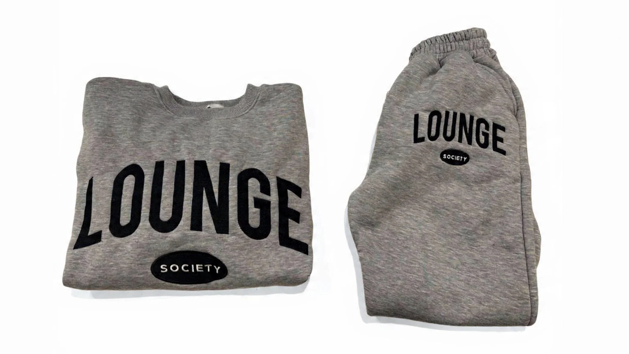 Gray sweatshirt and matching sweatpants with the words "LOUNGE SOCIETY" printed on both in black, laid flat on a white background.