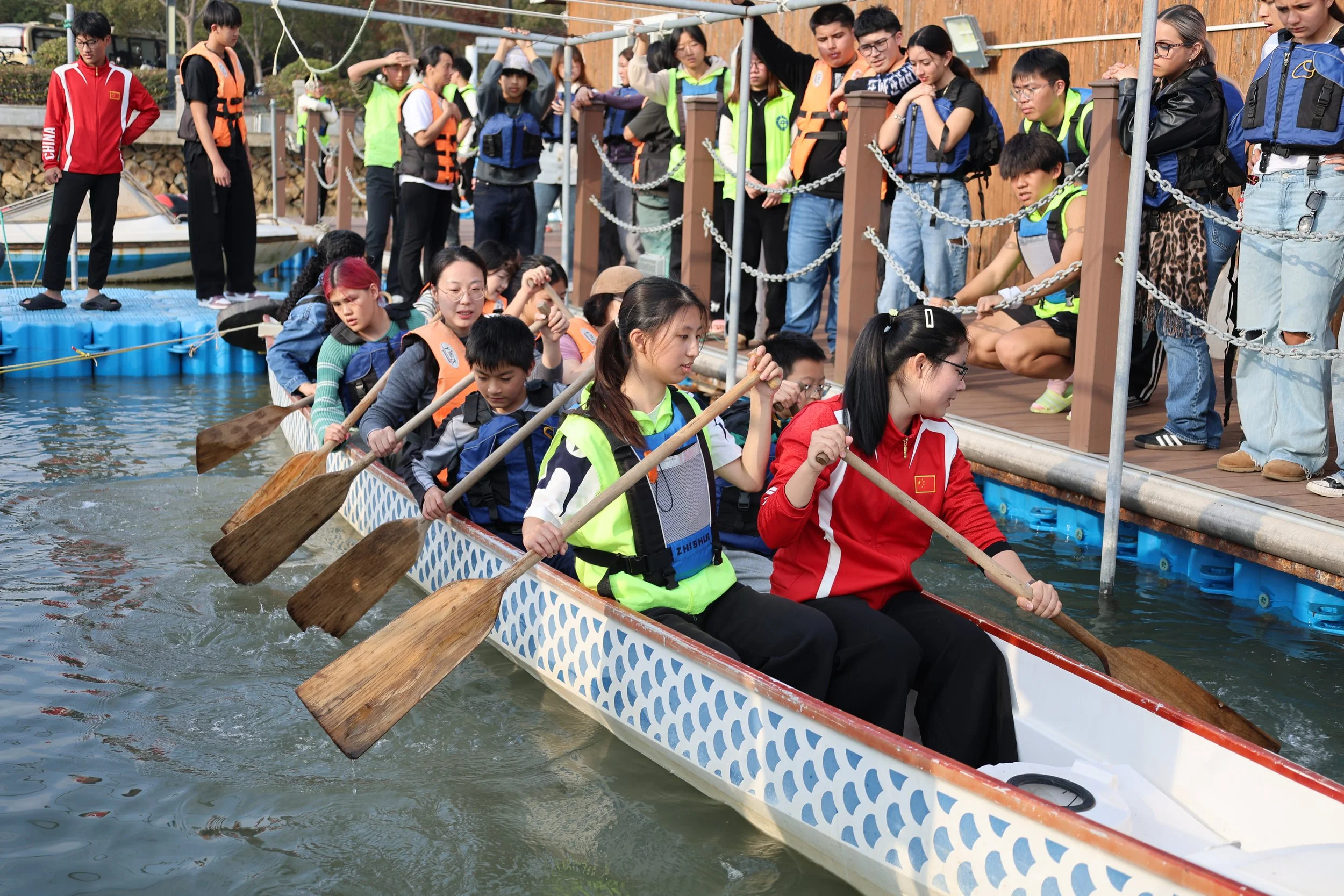 A group of young people participating in dragon boat paddling and racing.