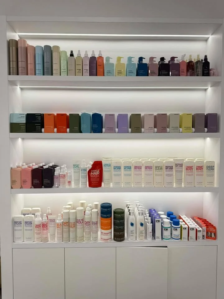 Shelves with various hair and body care products, including sprays, bottles, and tubes in different colors.