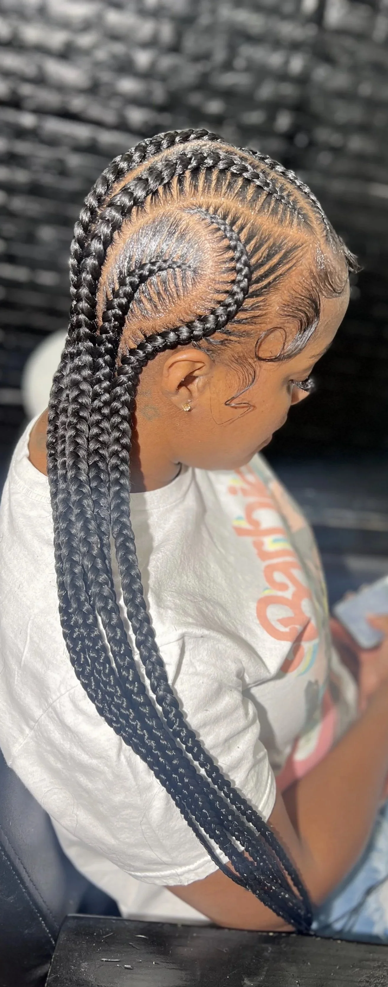 A woman with neatly done box braids styled into a spiral design.