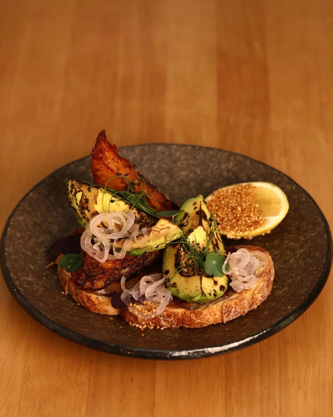 Avo toast, but make it artisanal. 🥑✨ Meet the new Coal Smoked Avocado Toast perfectly smoked and topped with black garlic emulsion, pickled shallot and house-made beef fat hash brown. 🔥