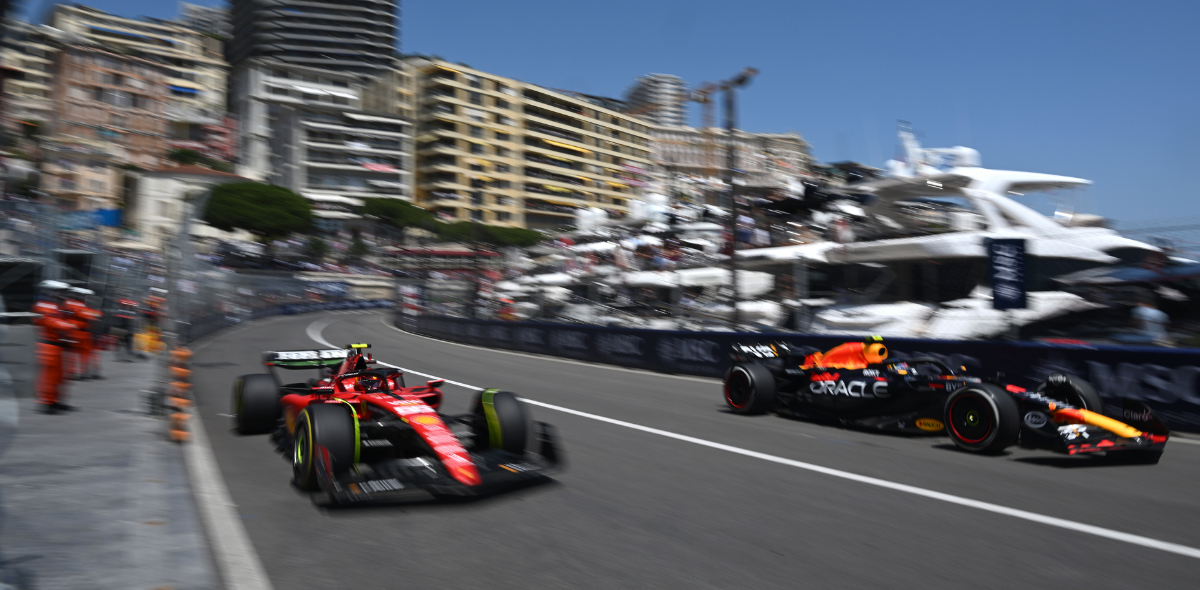 Formula 1 cars racing past Monaco harbor during Grand Prix weekend