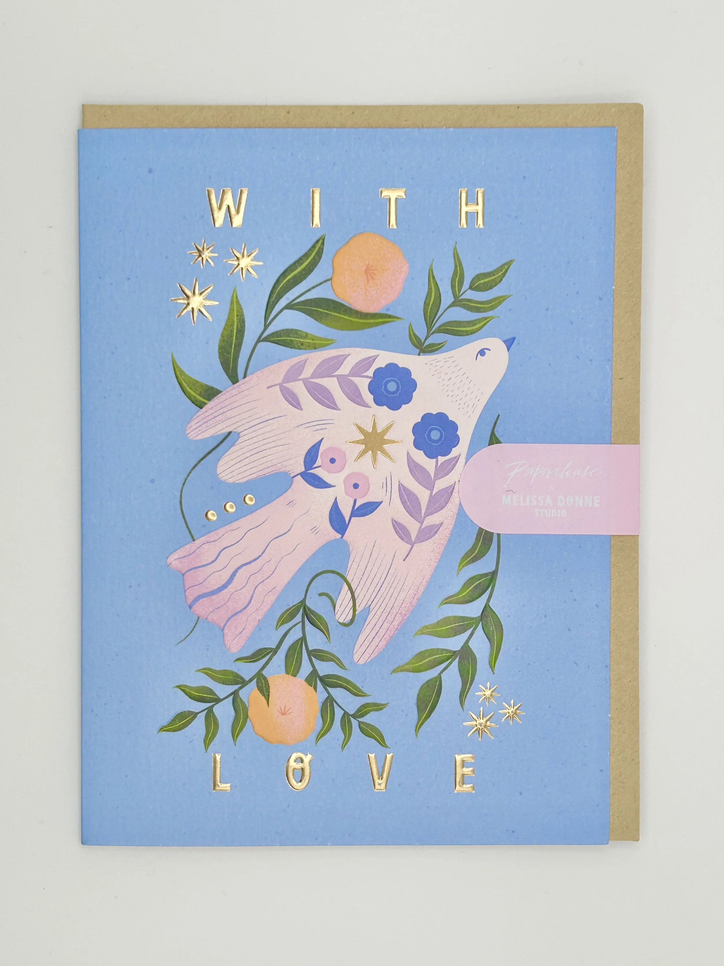 A greeting card with a blue background and a pink dove surrounded by green leaves, orange flowers, and gold stars. The words 'WITH LOVE' are at the top and bottom of the card in gold letters. A pink label on the right side reads 'Papaya Seed MELISSA 