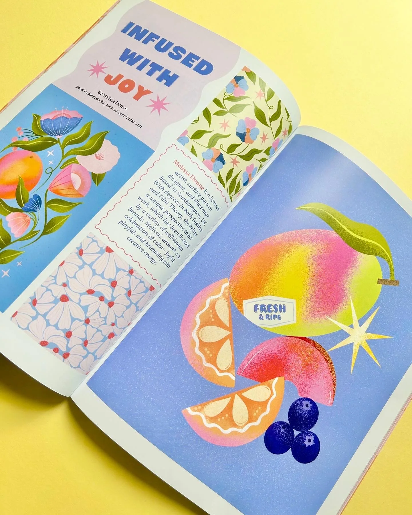 Open booklet featuring colorful illustrations of sliced oranges, peaches, and blueberries with a star shape, against a blue background, and a label reading 'Fresh & Ripe.' The left page has decorative floral patterns and text about artist Melissa Donn. The top of the left page has bold text 'Infused with Joy.'