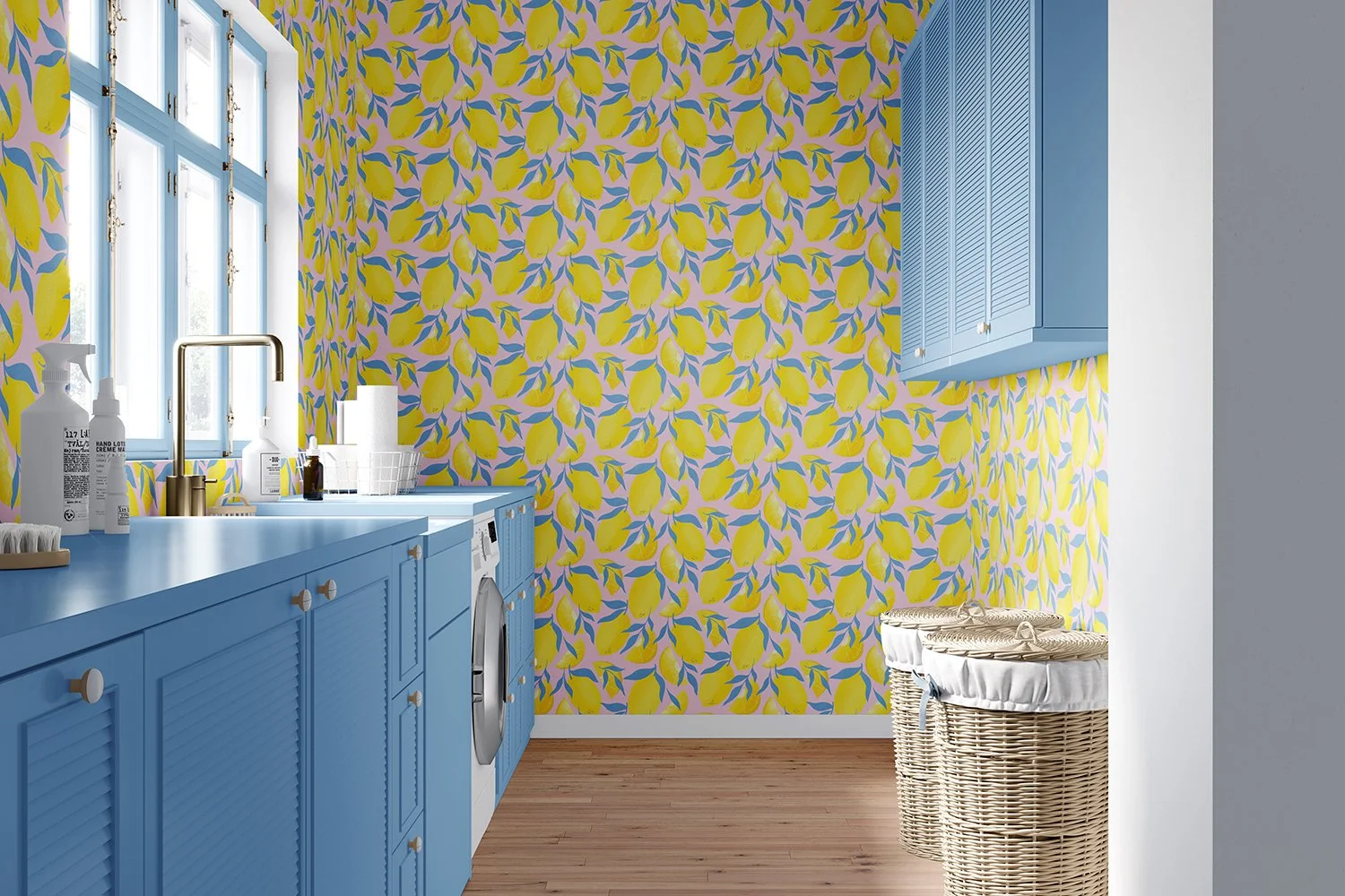 A laundry room with blue cabinets and countertops, a yellow lemon-patterned wallpaper, a window, and a woven laundry basket.
