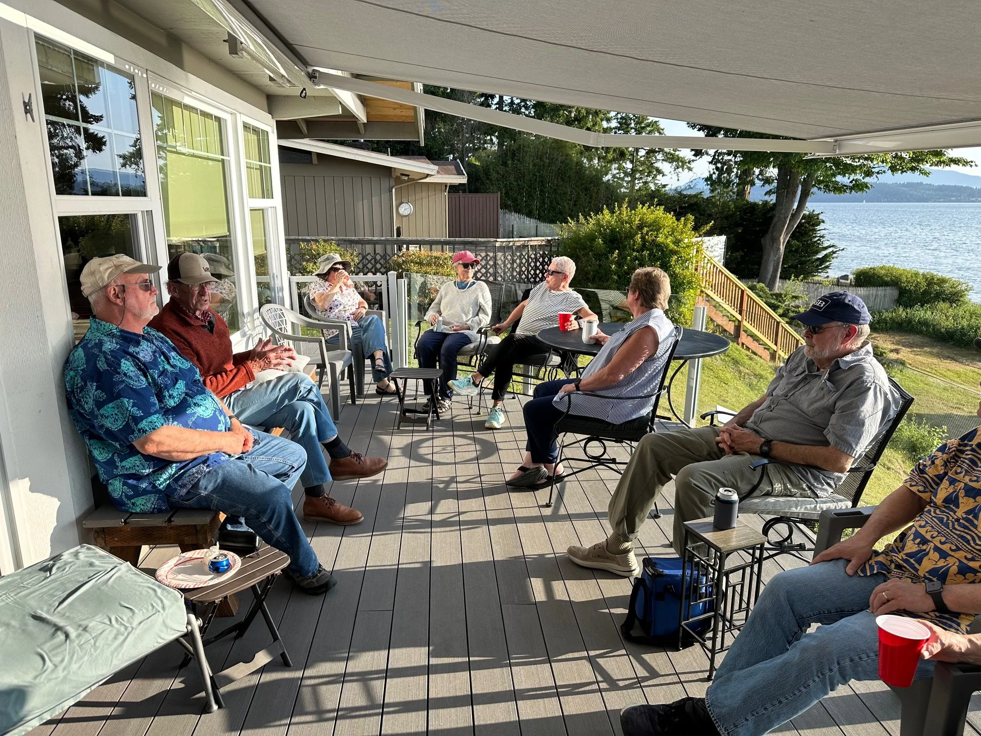 Squalicum Yacht Club members gather at the annual Summer Solstice party, sitting on the deck eating, drinking, and talking.