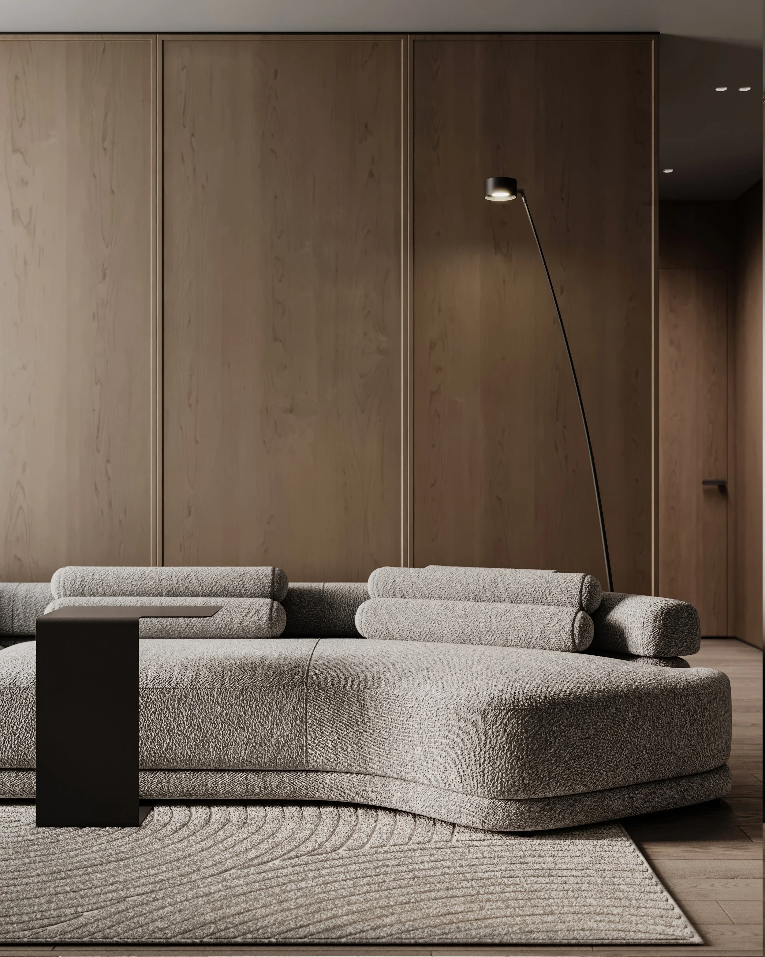 Modern living room with a textured light gray sectional sofa, black side table, wooden wall paneling, and a black floor lamp with a curved arm.