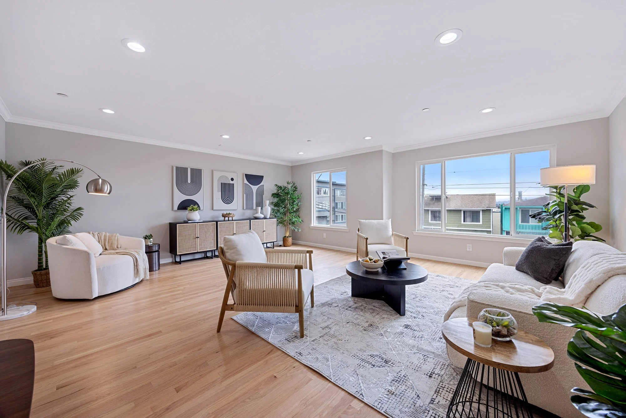 Bright staged living room with modern furniture, large windows, and natural light in renovated San Francisco home