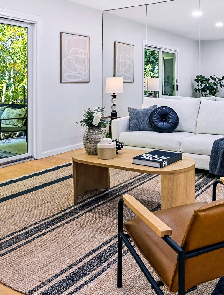 Modern staged living room with sofa, coffee table, and balcony doors in San Francisco home