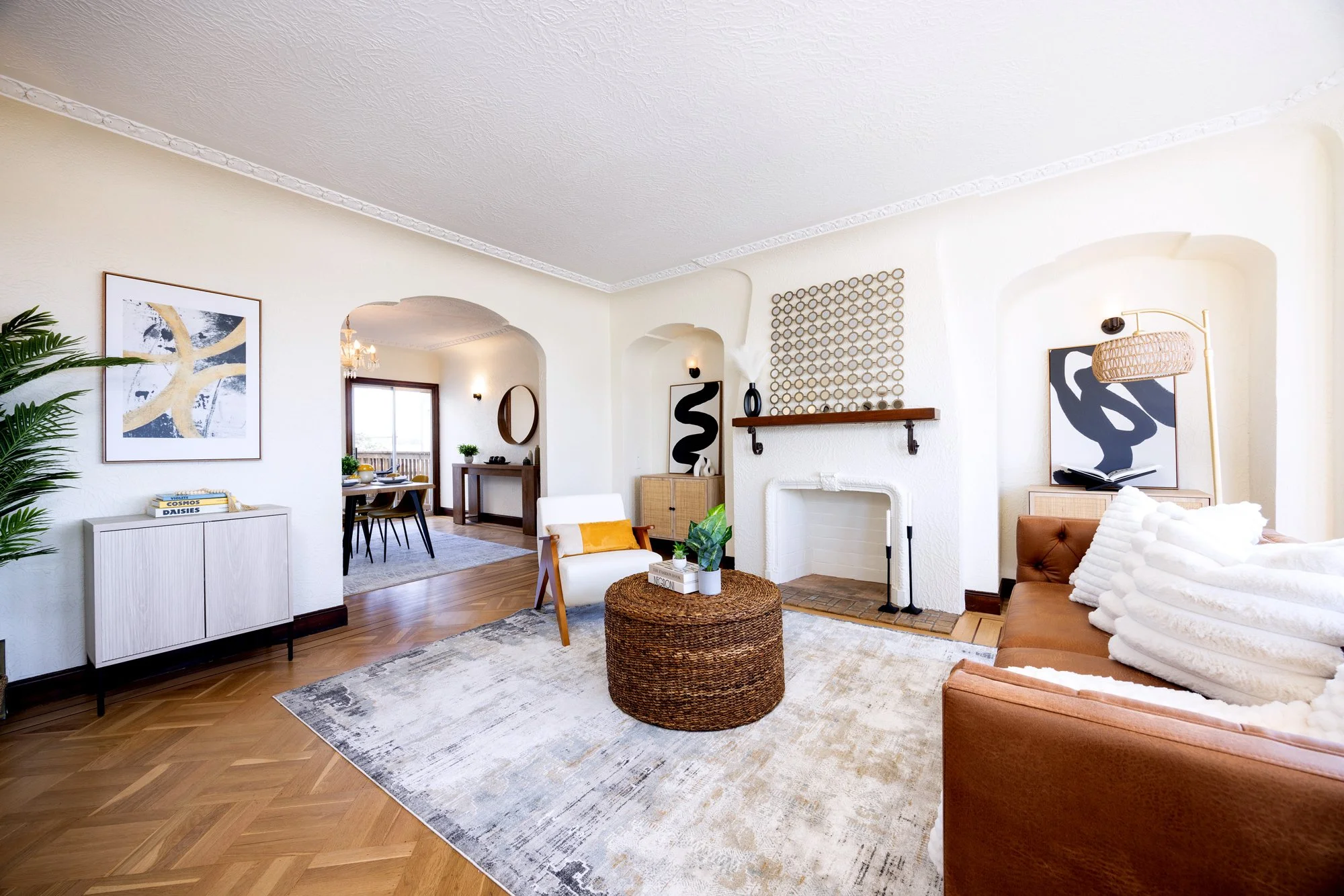 Staged living room with brick fireplace, wood trim, and open view into dining room