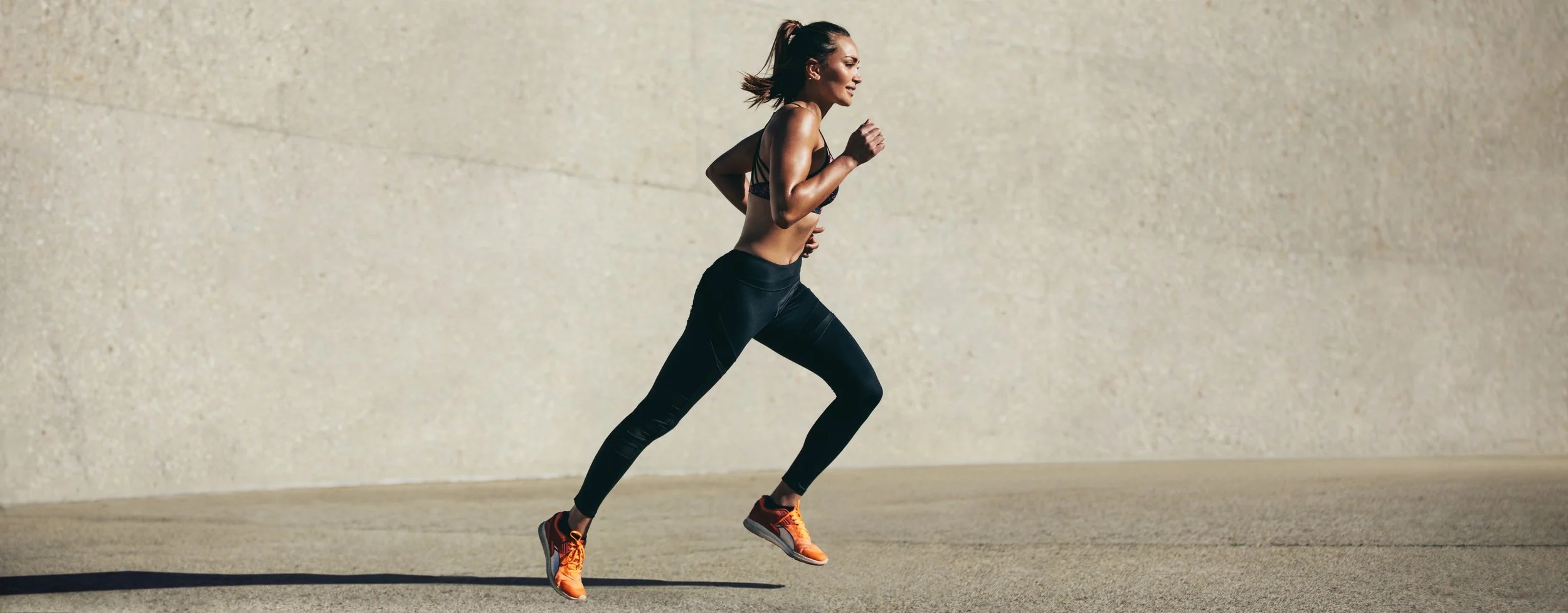 Woman running in licensed premium fitness apparel